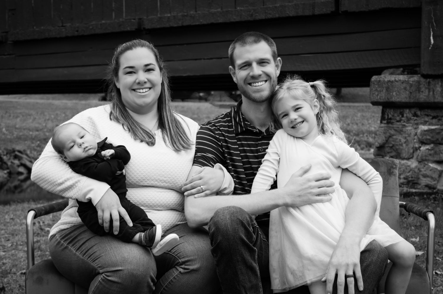 A series of black and white family portraits showing candid moments of people sitting together outdoors.