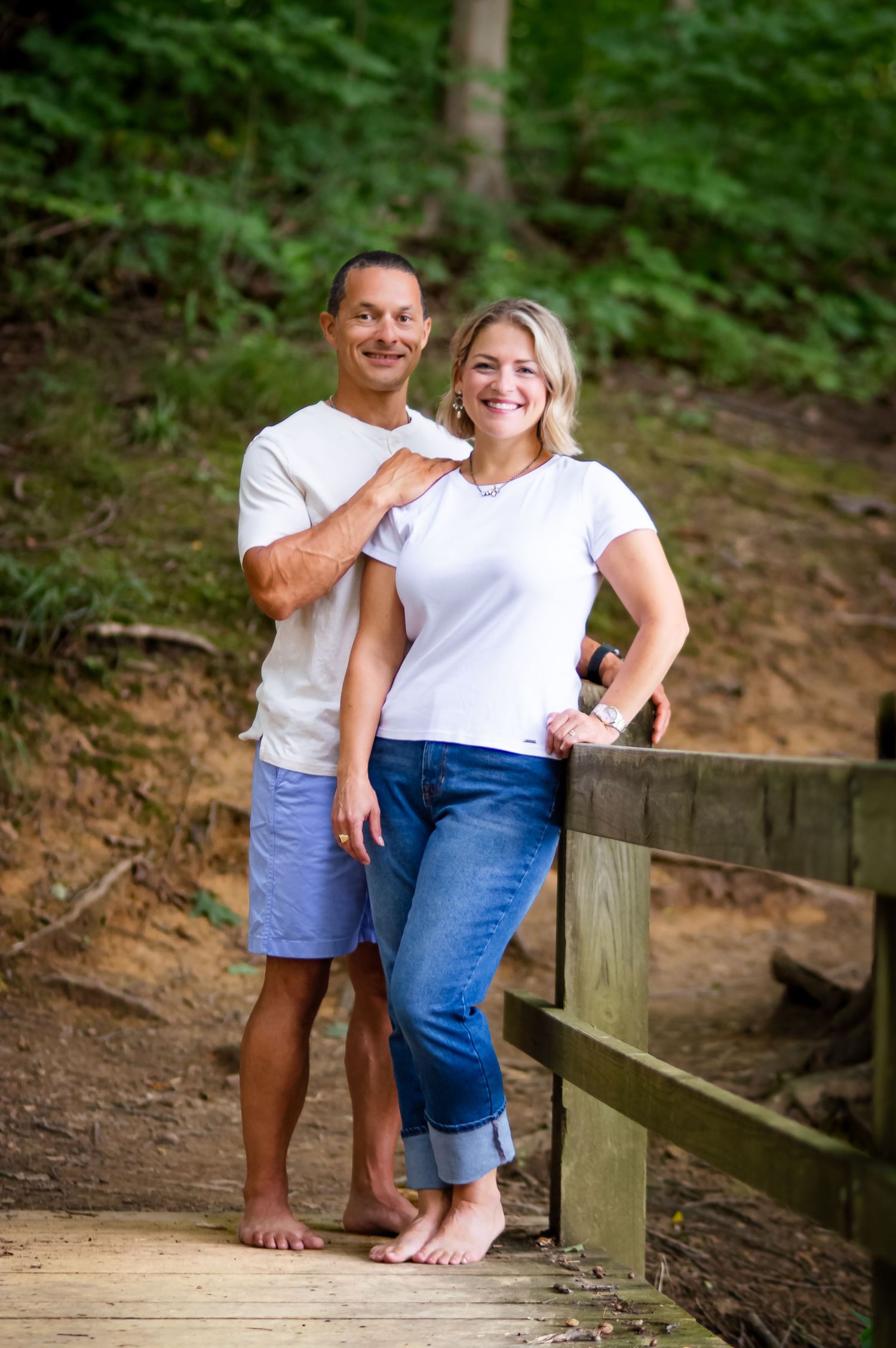 Family enjoying casual moments together on wooden walkway in nature setting.