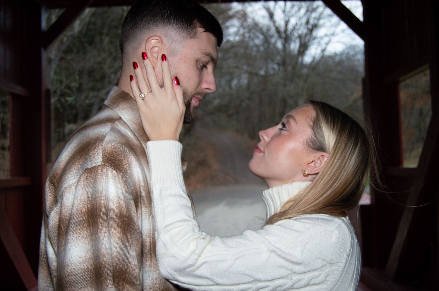 A romantic moment shared between a couple on a couch in a natural outdoor setting.