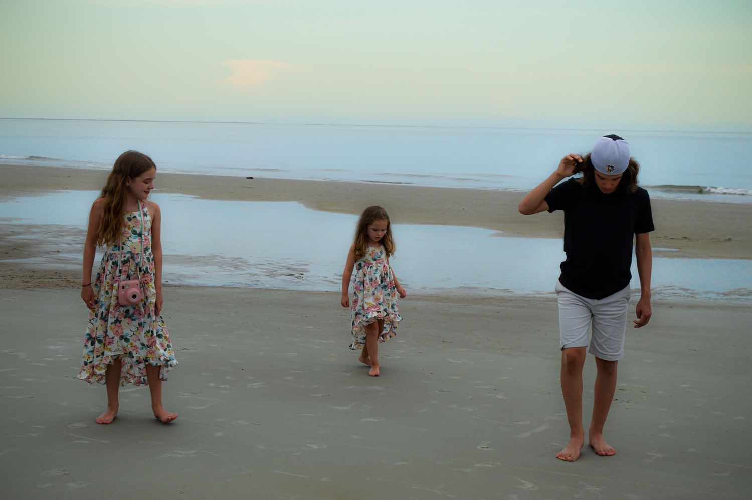 A family enjoys time together on an empty beach during golden hour.