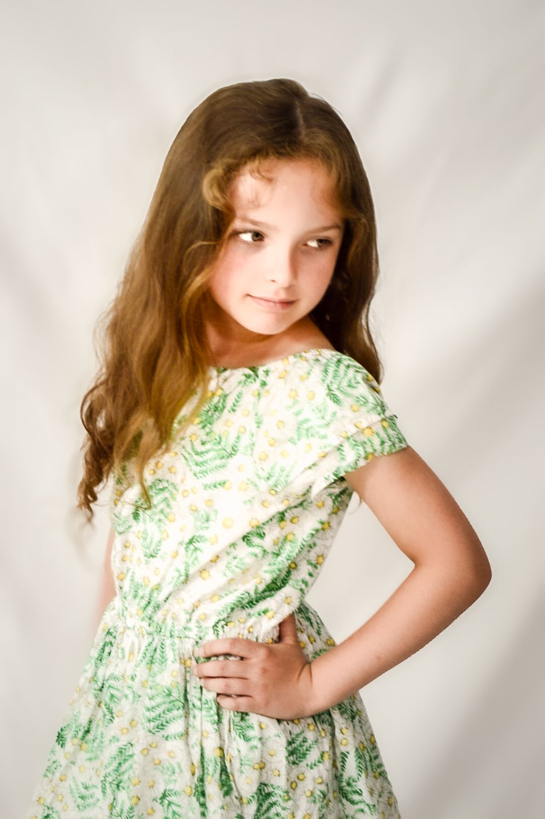 A series of four photos showing someone in a floral green and white dress against a light background.