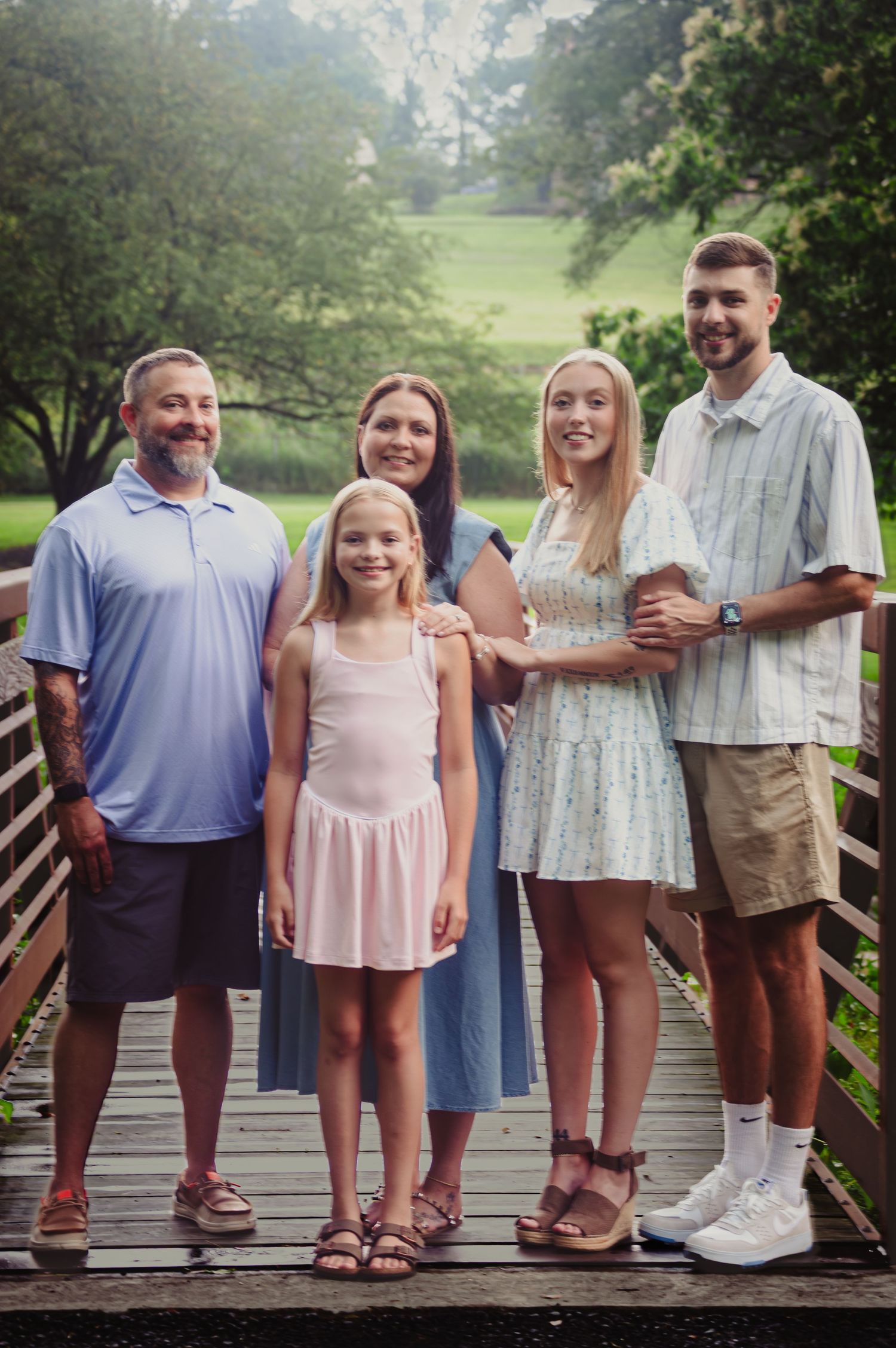 A series of cropped family photos showing people standing together on a wooden bridge in an outdoor setting.