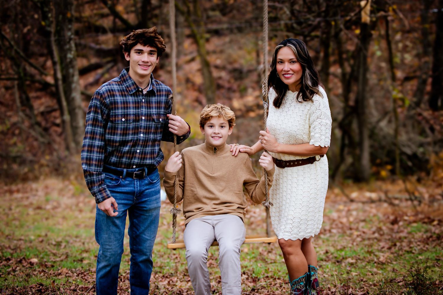 Family walking together on autumn forest path surrounded by colorful fall foliage.