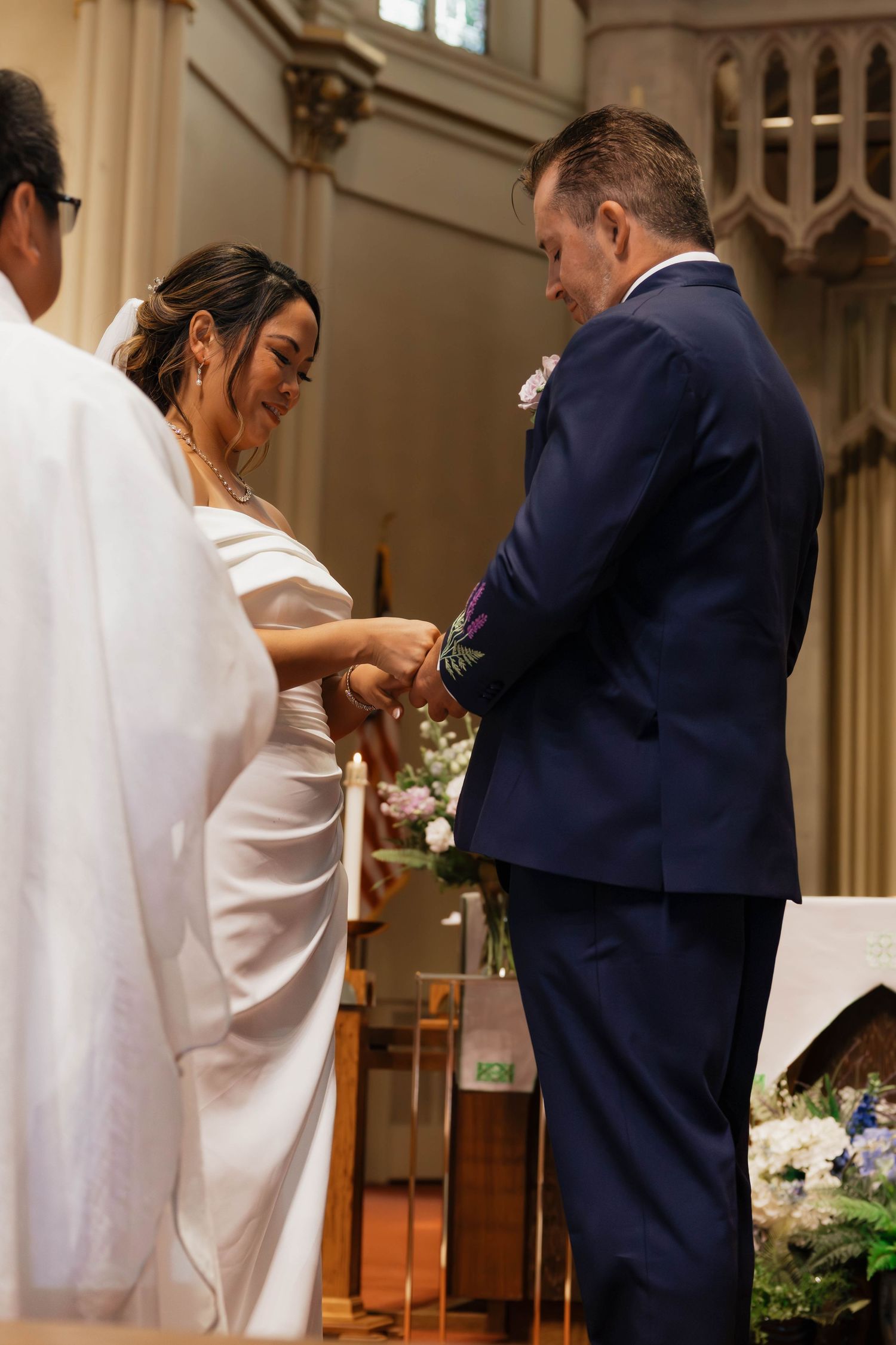 Bride and groom exchange rings at church altar during their traditional wedding ceremony.