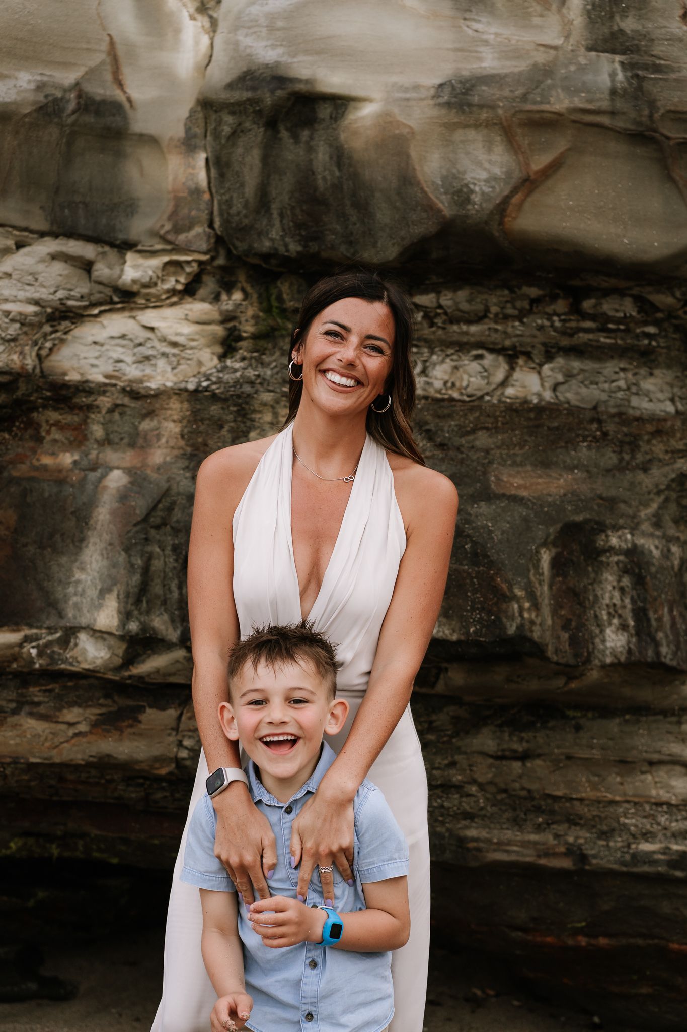 mum cuddling laughing son during family photoshoot