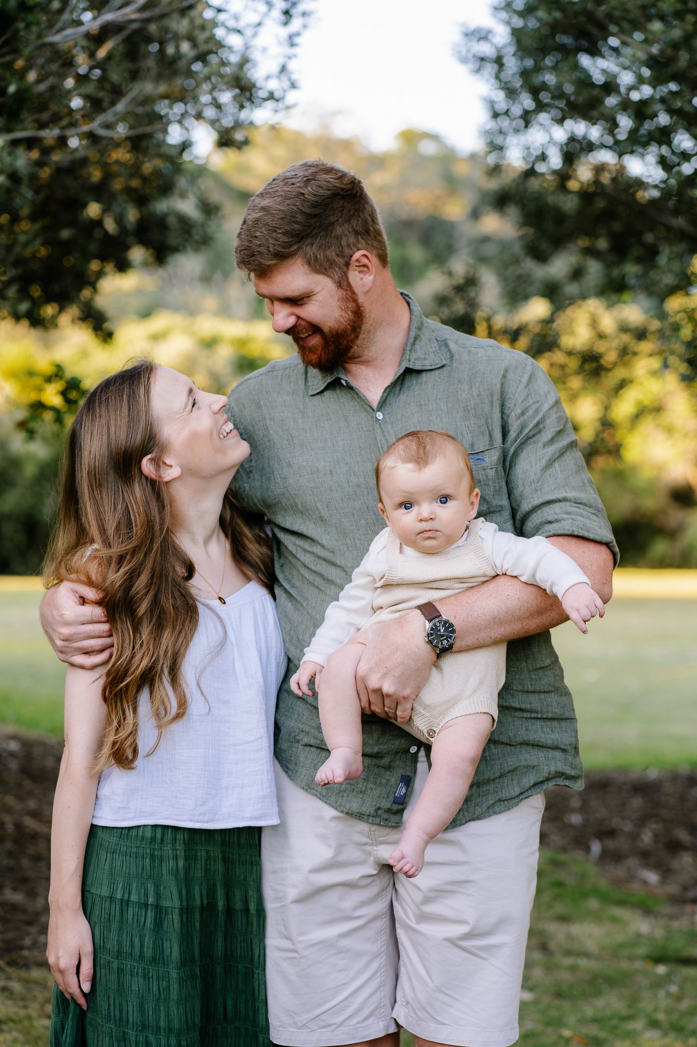family photography of dad looking at mum whilst holding baby