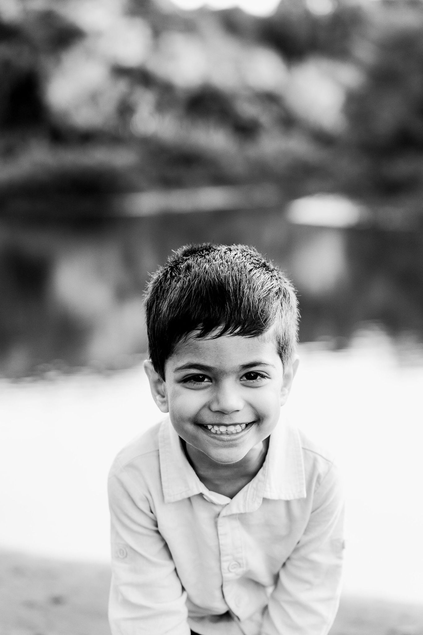 Family outdoor session with young children, capturing playful and tender moments in a softly lit, minimal setting.