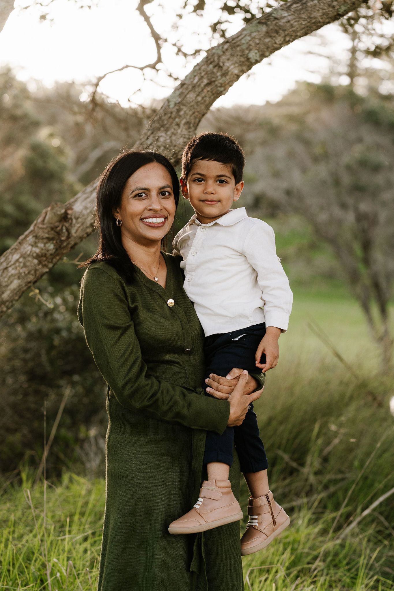 Family outdoor session with young children, capturing playful and tender moments in a softly lit, minimal setting.