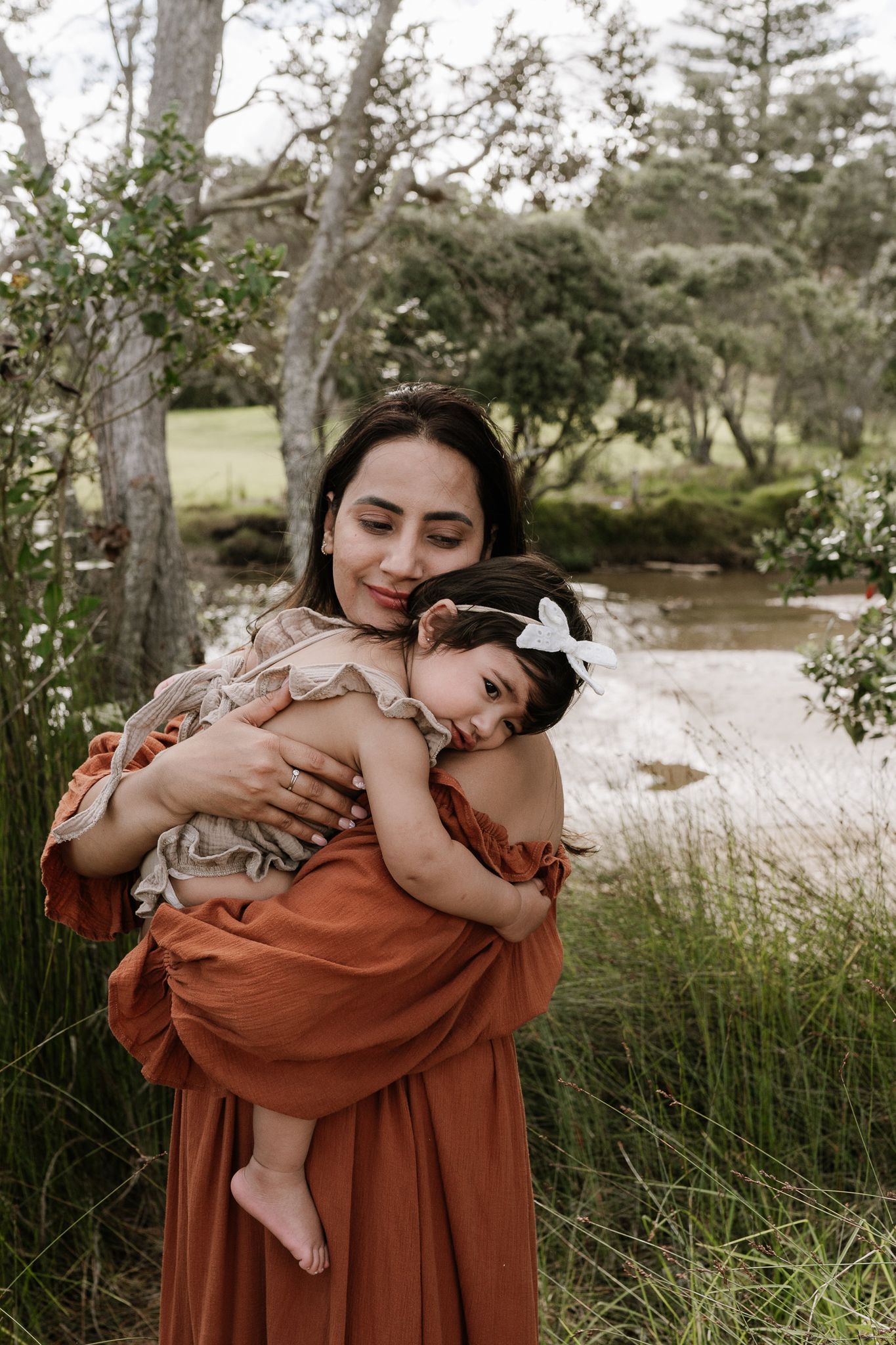 Family outdoor session with young children, capturing playful and tender moments in a softly lit, minimal setting.