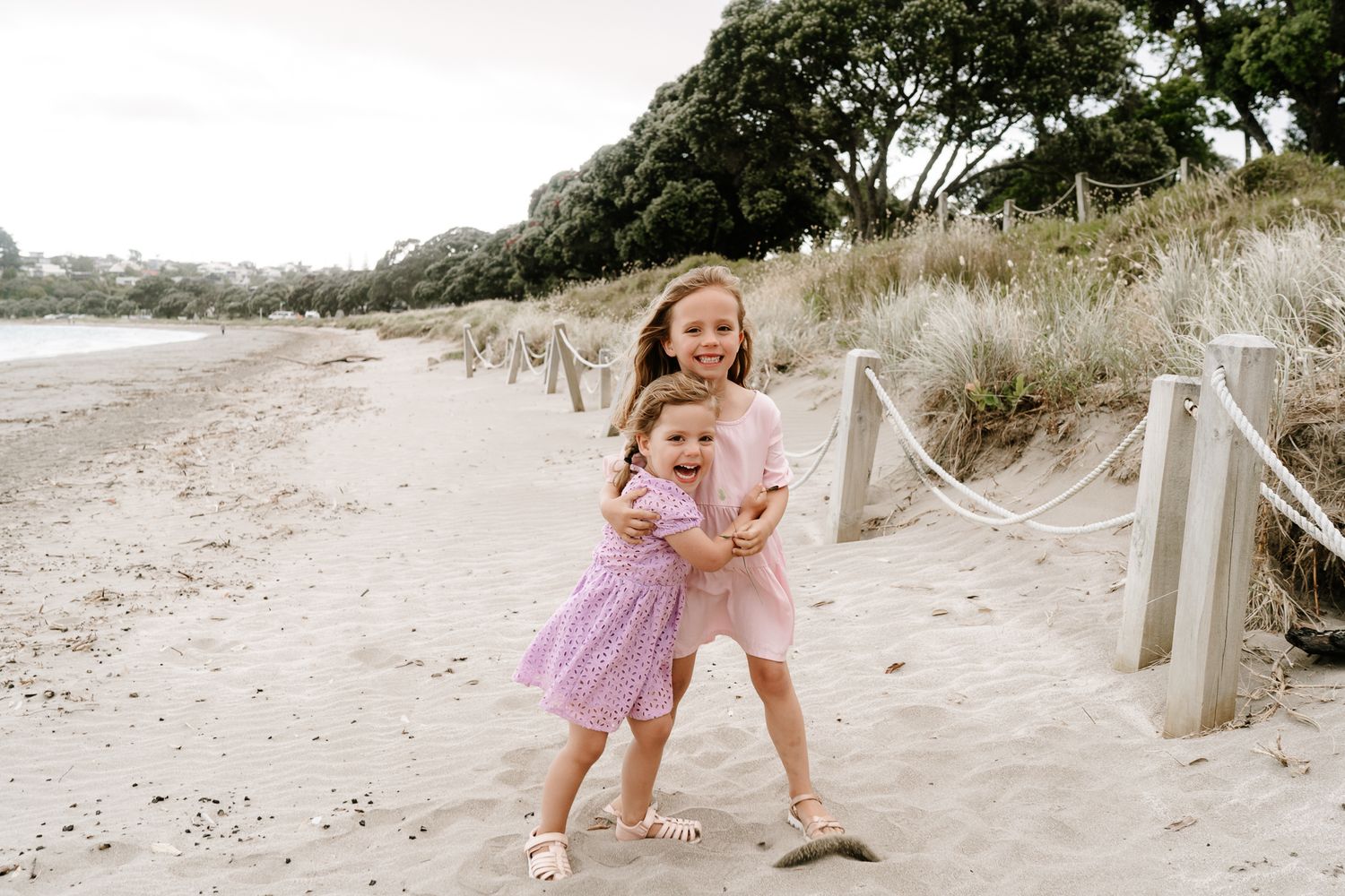 Family photography session with two young children playing and cuddling outdoors. Natural light, joyful expressions, and candid
