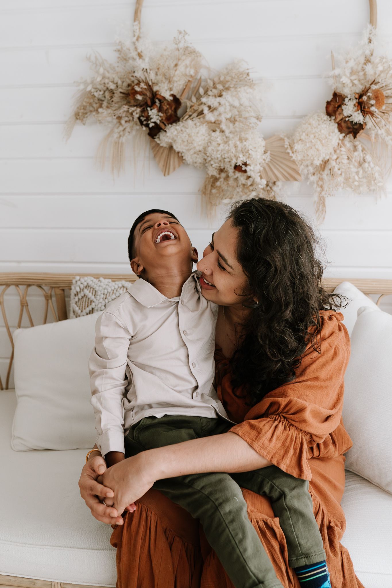 Family studio session with young children, capturing playful and tender moments in a softly lit, minimal setting.