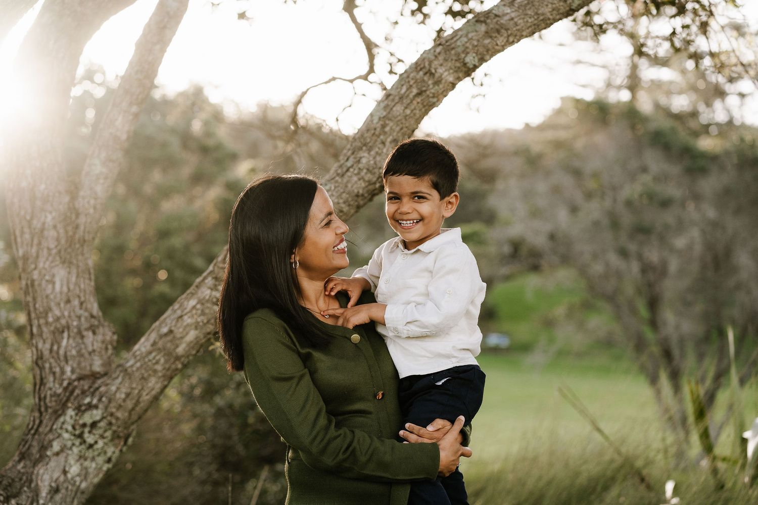 Family outdoor session with young children, capturing playful and tender moments in a softly lit, minimal setting.