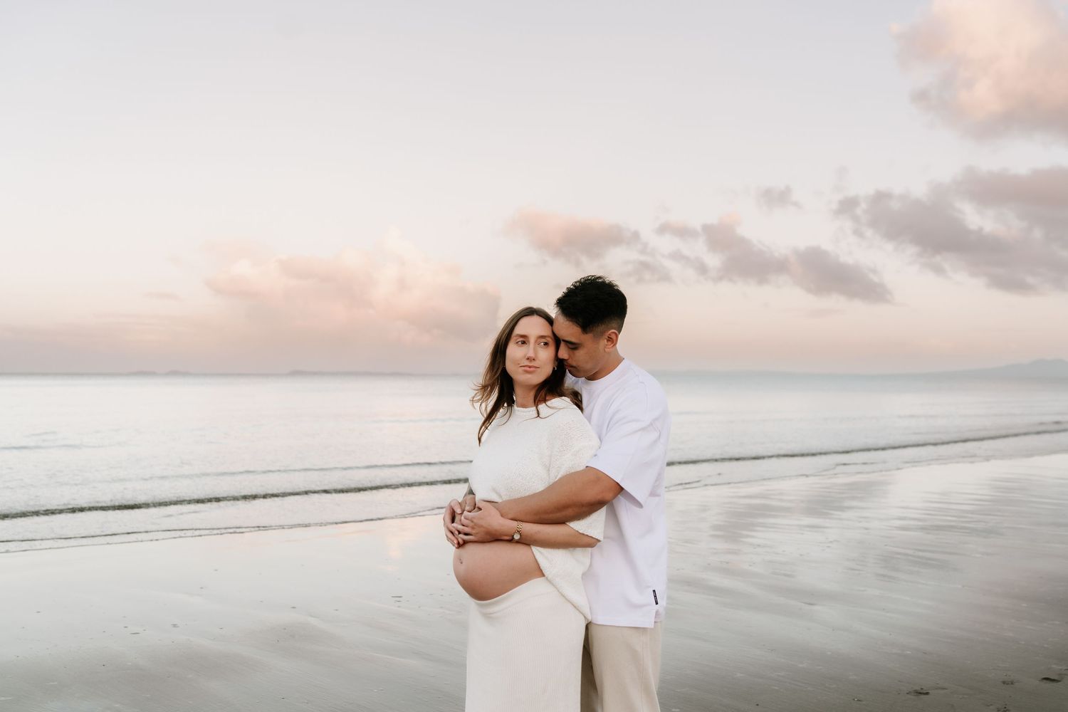 Stunning maternity reflections in the tide at sunset. Bold and modern beach photography by Little Wild Ones, Auckland.