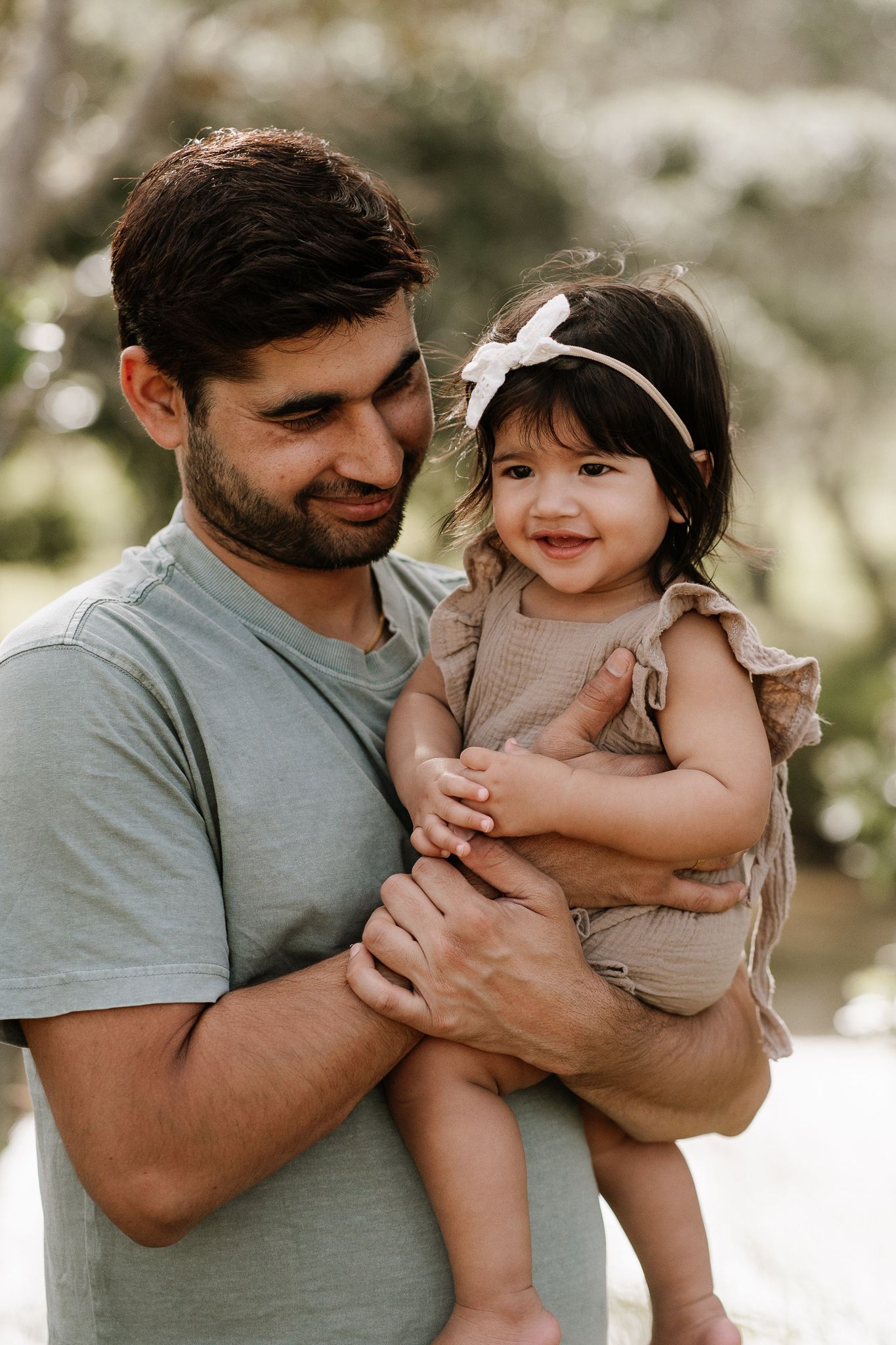 Family outdoor session with young children, capturing playful and tender moments in a softly lit, minimal setting.