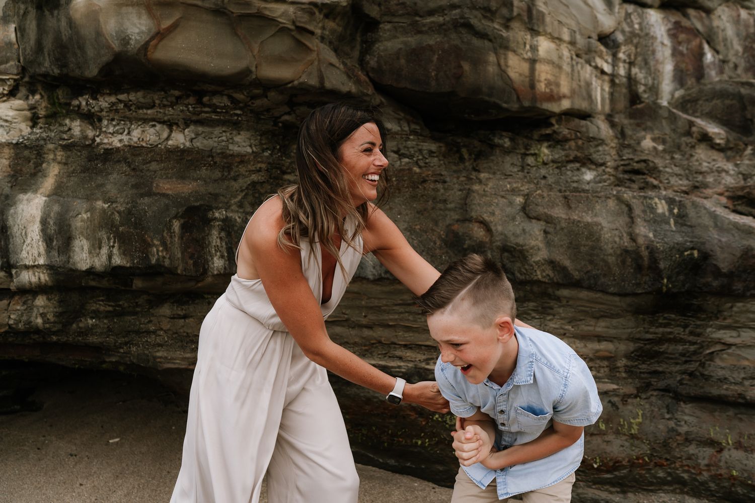 mum cuddling laughing son during family photoshoot