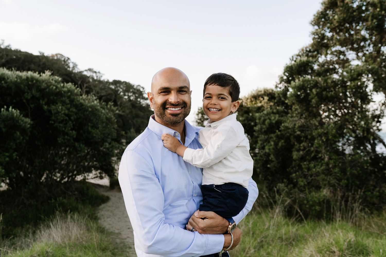 Family outdoor session with young children, capturing playful and tender moments in a softly lit, minimal setting.