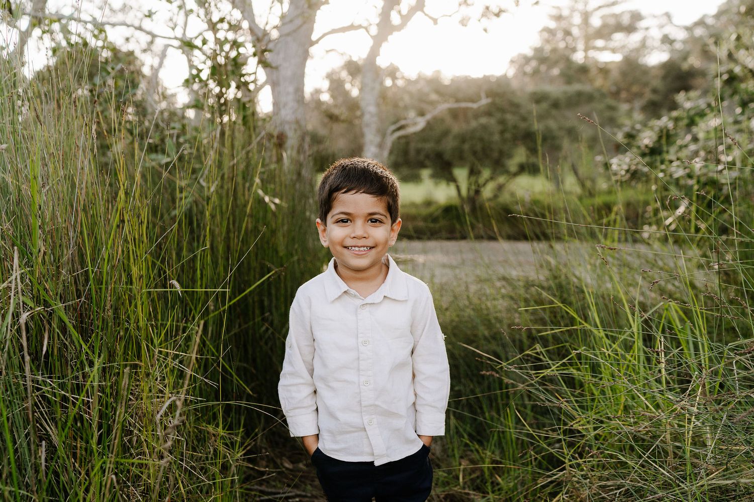 Family outdoor session with young children, capturing playful and tender moments in a softly lit, minimal setting.