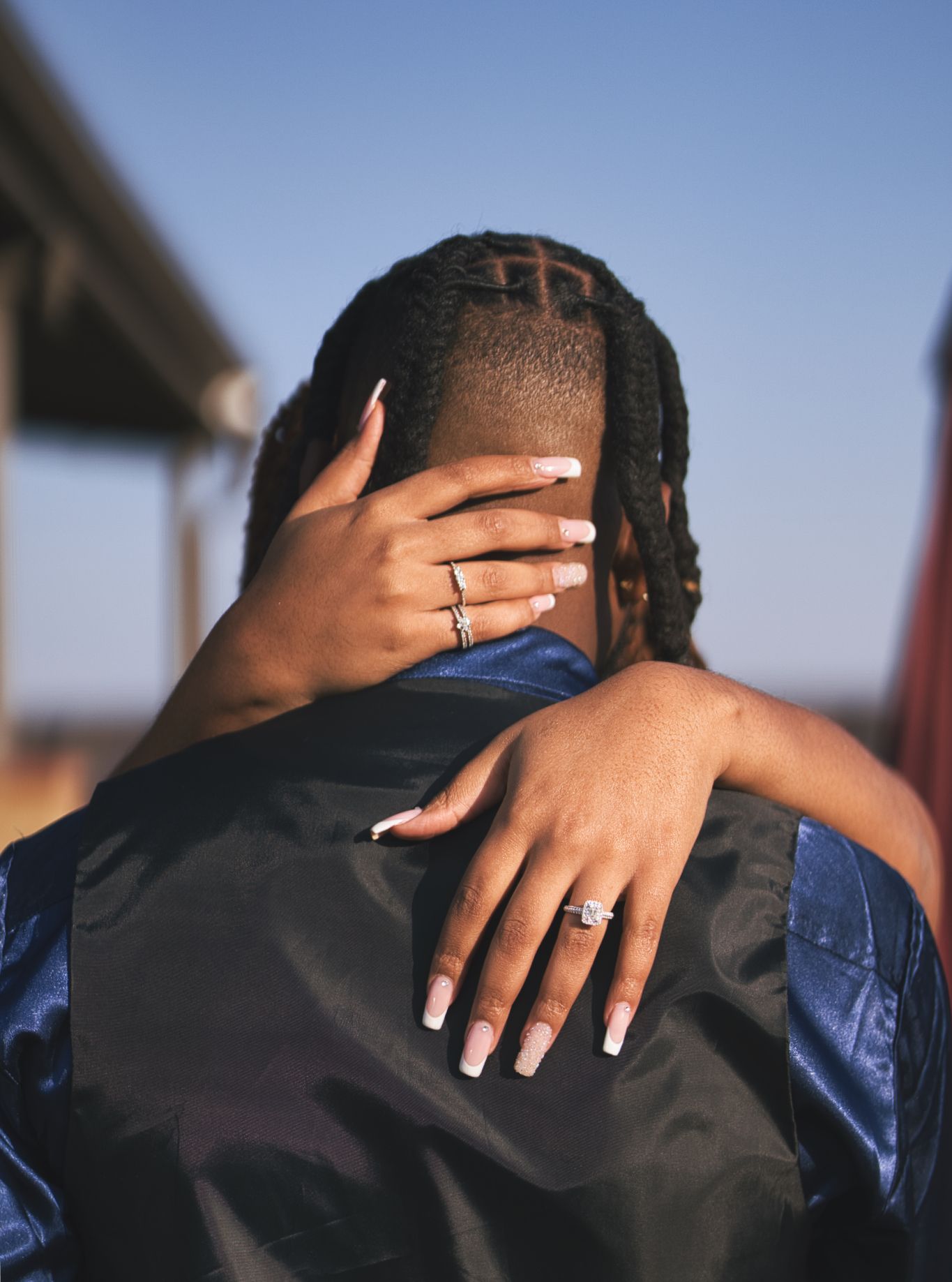 A series of close-up shots showing hands with white nail polish embracing someone wearing a blue shirt.