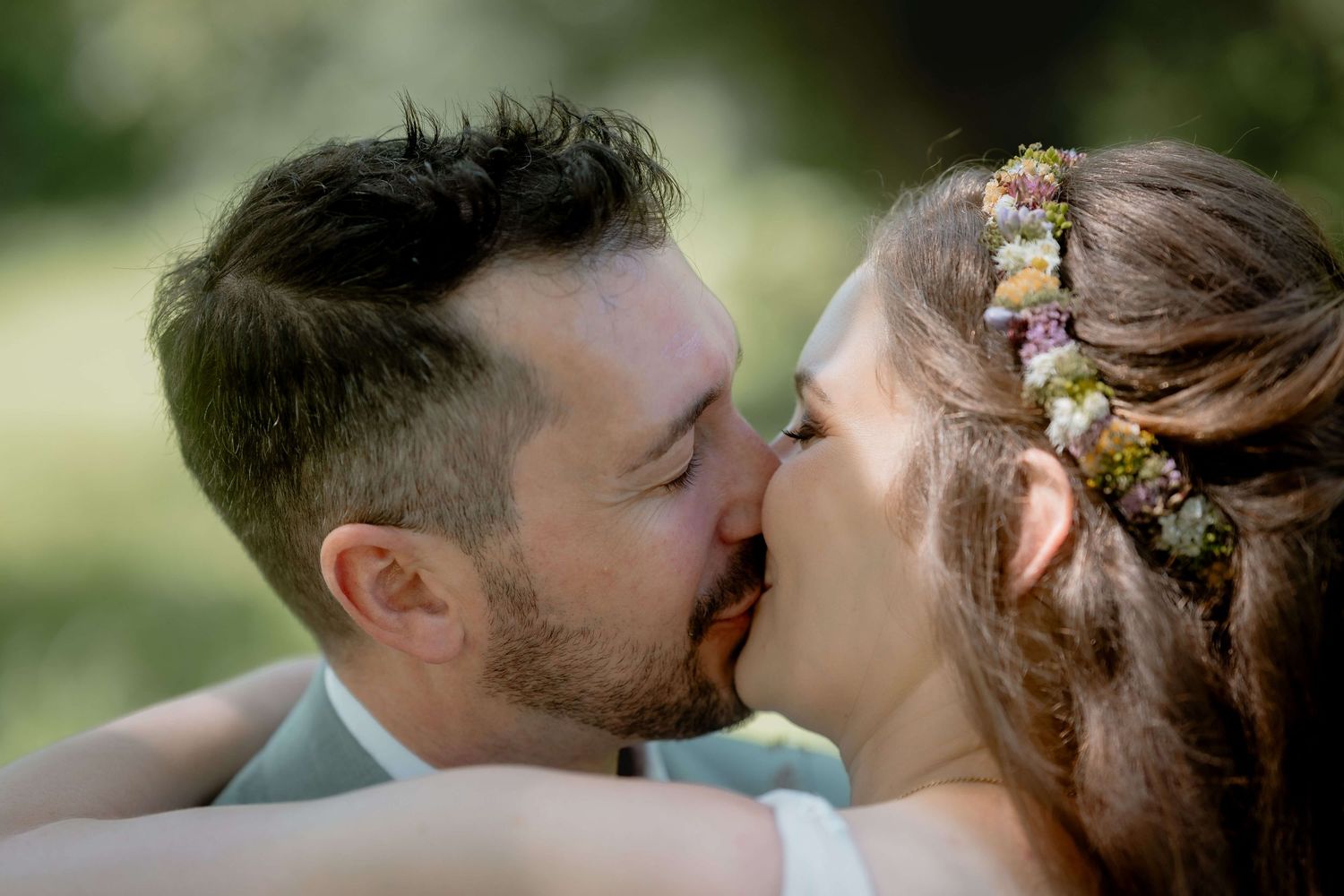 Anna und Markus teilen einen Kuss im Freien – authentische und gefühlvolle Hochzeitsfotografie in Vorarlberg von NuMa Fotografie