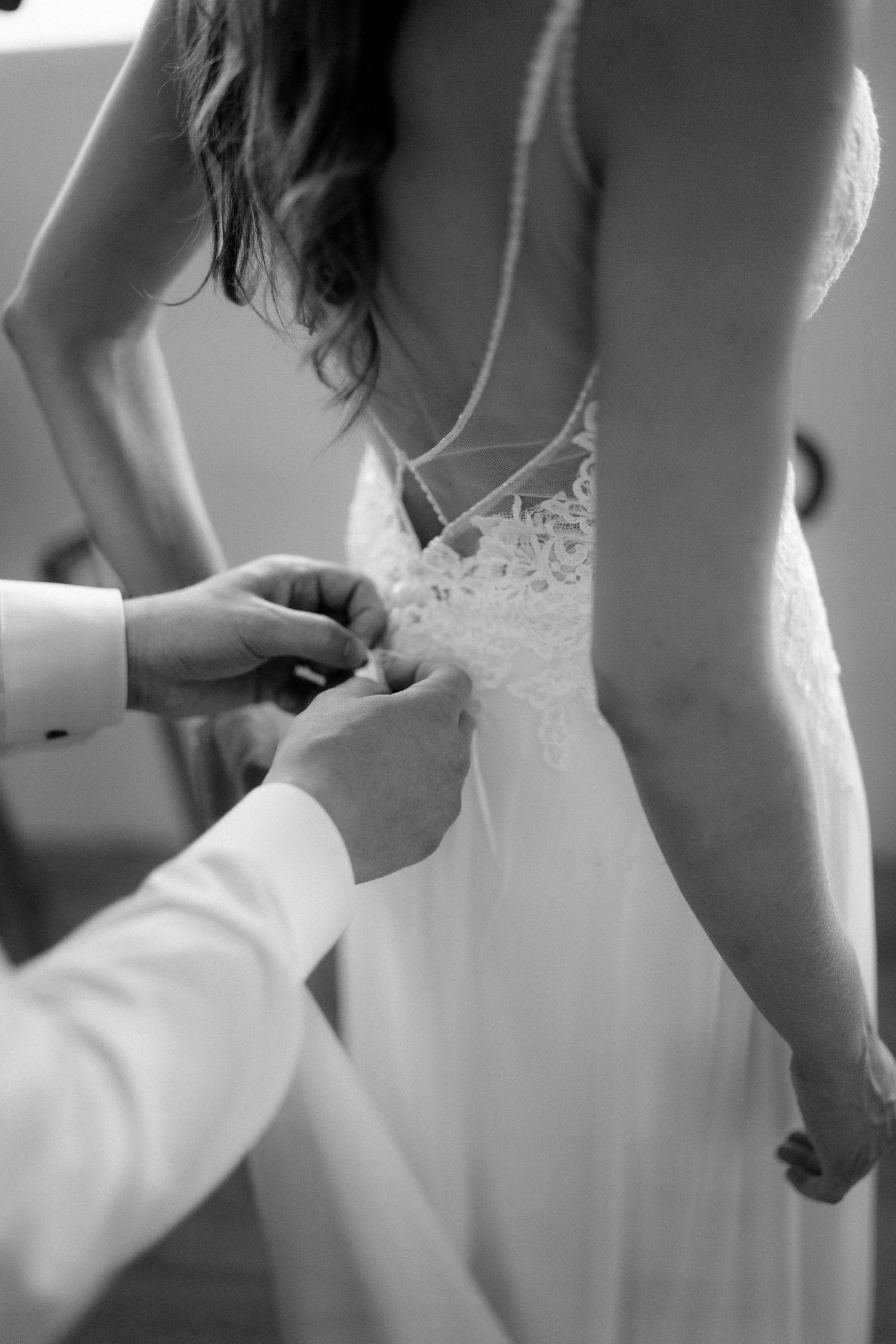 Ein kunstvoller Blick auf das Brautkleid und feine Details, eingefangen von NuMa Fotografie bei der Vorarlberger Hochzeit