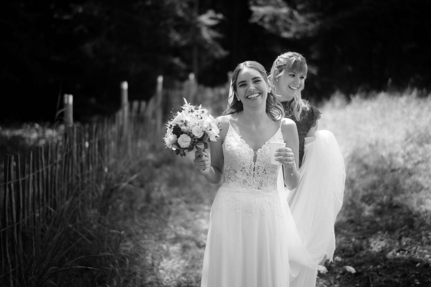 Lachende Braut mit Blumenstrauß und ihrer Trauzeugin auf dem Weg zur Trauung – festgehalten von NuMa Fotografie