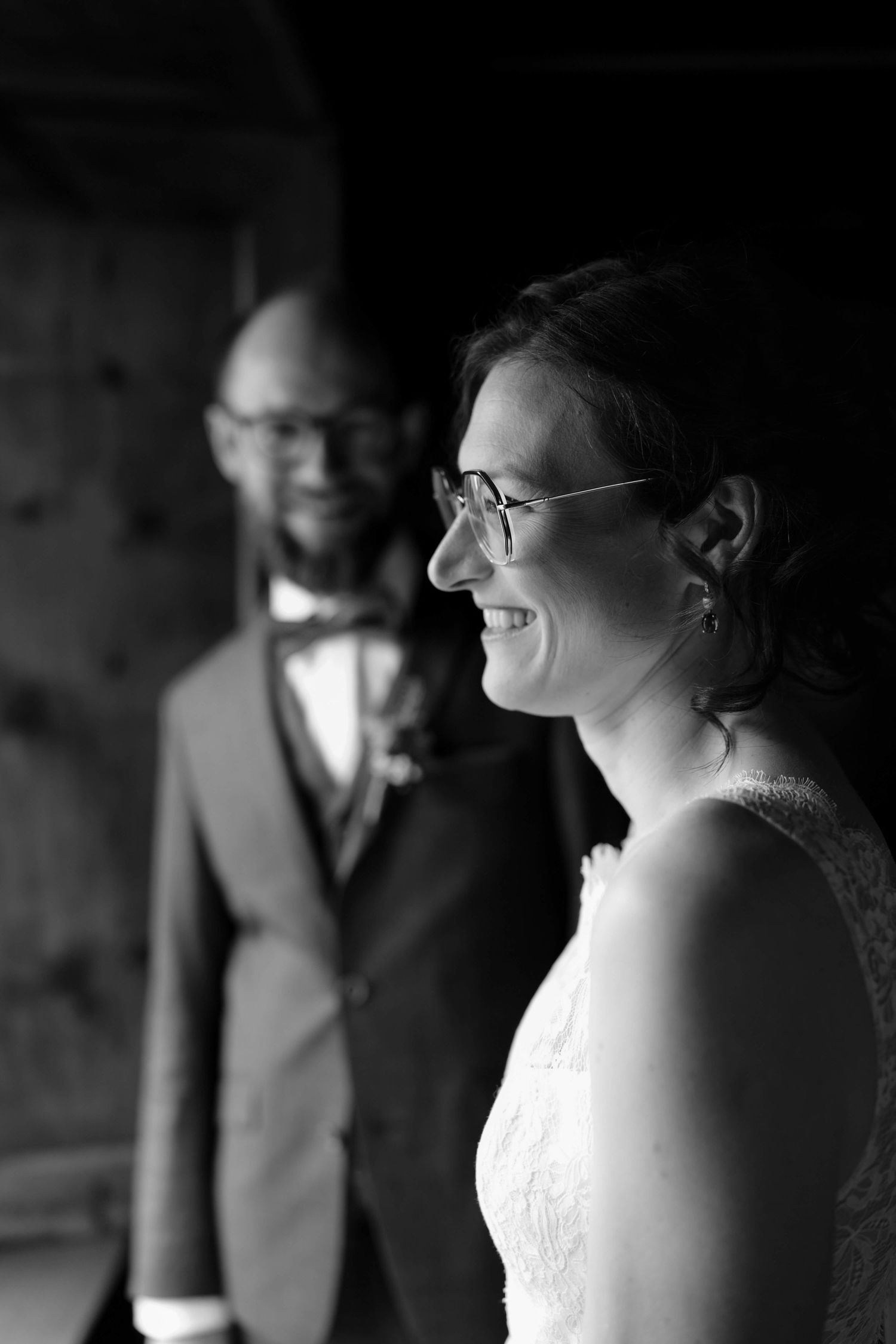 Die Braut blickt lächelnd aus dem Fenster – natürliche Lichtstimmung bei der Hochzeit in Vorarlberg, eingefangen von NuMa Fotografie