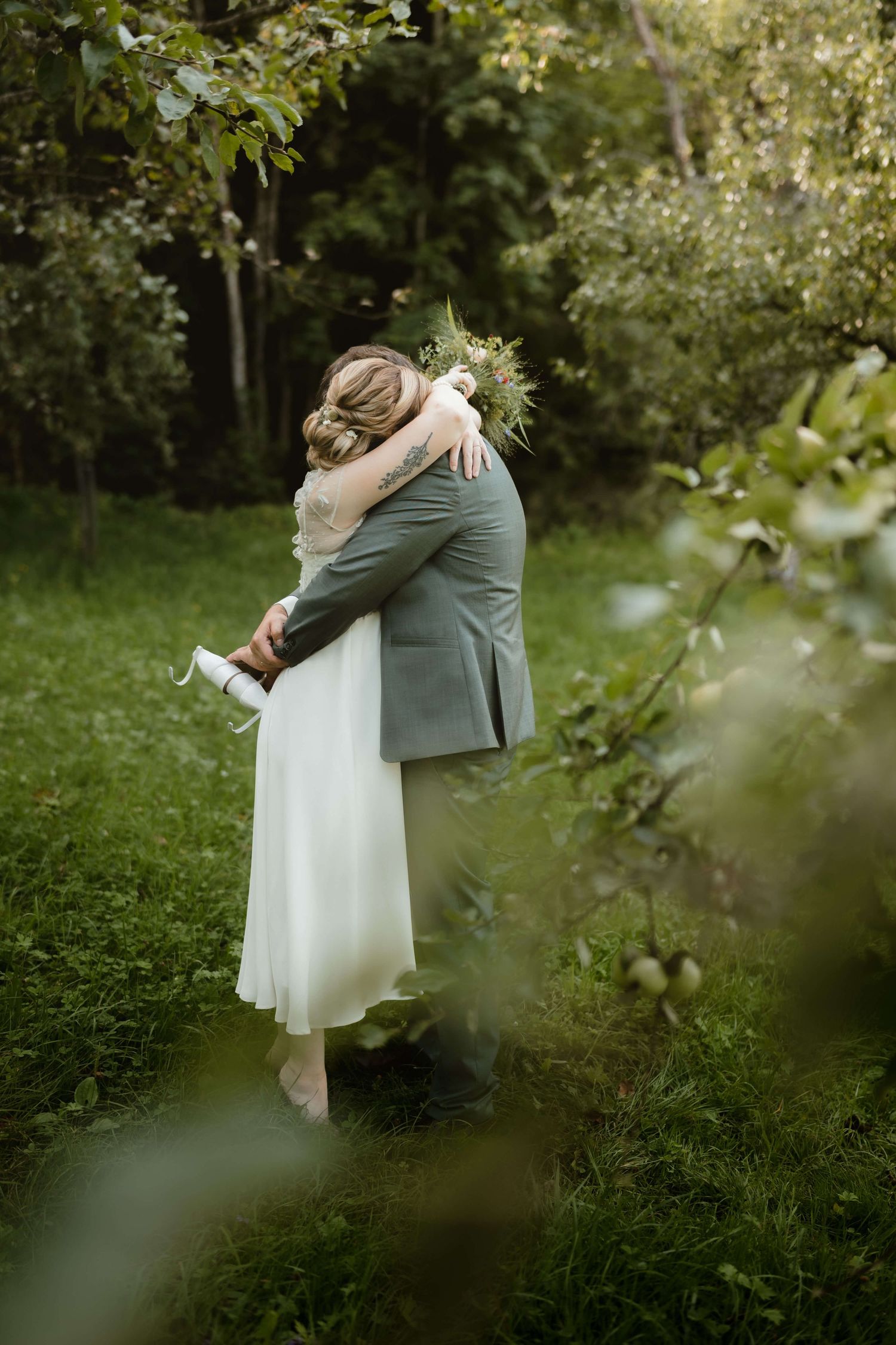 Emotionaler Moment im Obstgarten – Braut und Bräutigam umarmen sich innig bei ihrer Hochzeit in Vorarlberg, festgehalten von NuMa Fotografie