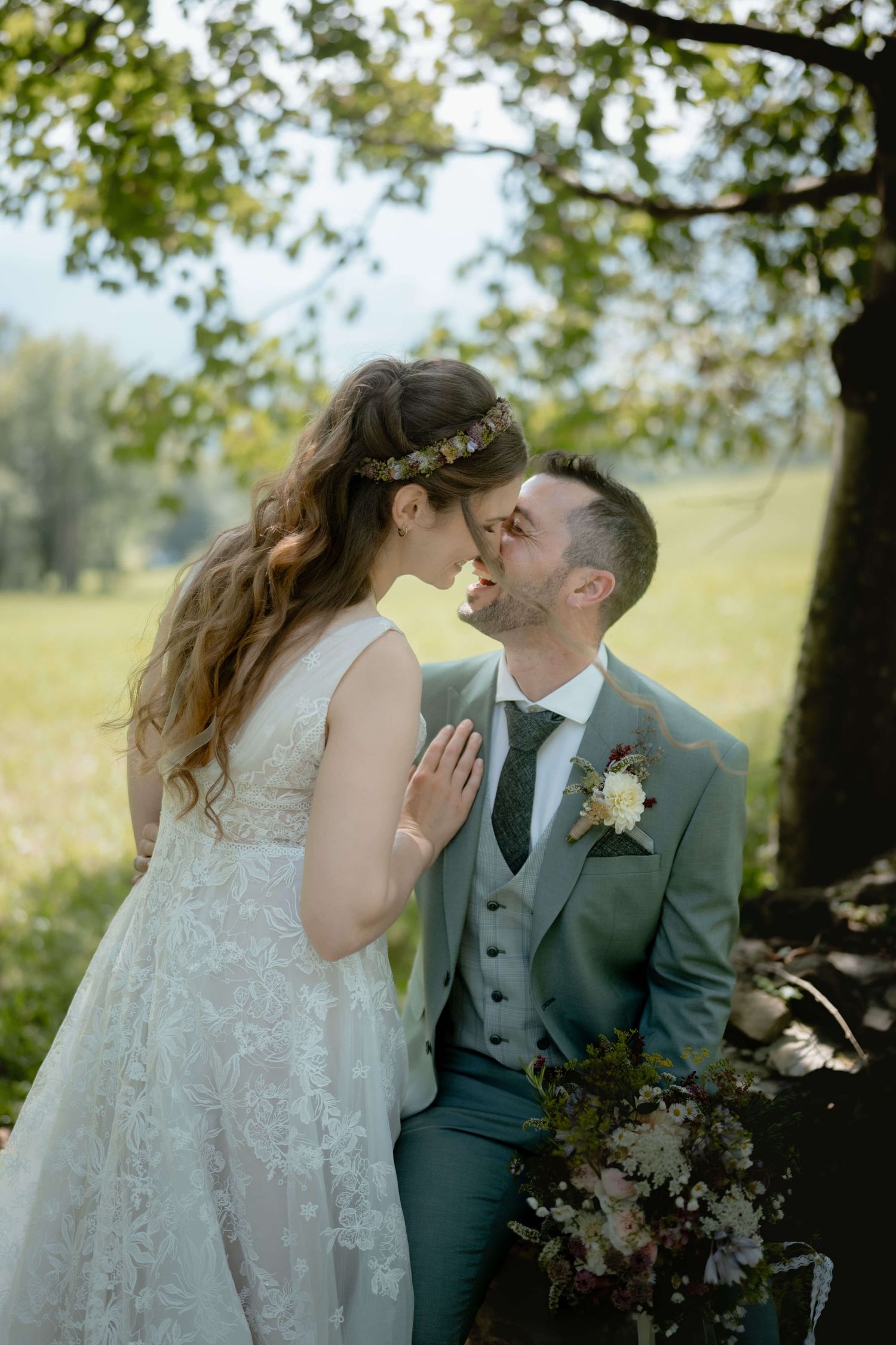 Anna und Markus teilen einen liebevollen Nasenkuss auf einer Sommerwiese in Vorarlberg – Hochzeitsreportage von NuMa Fotografie