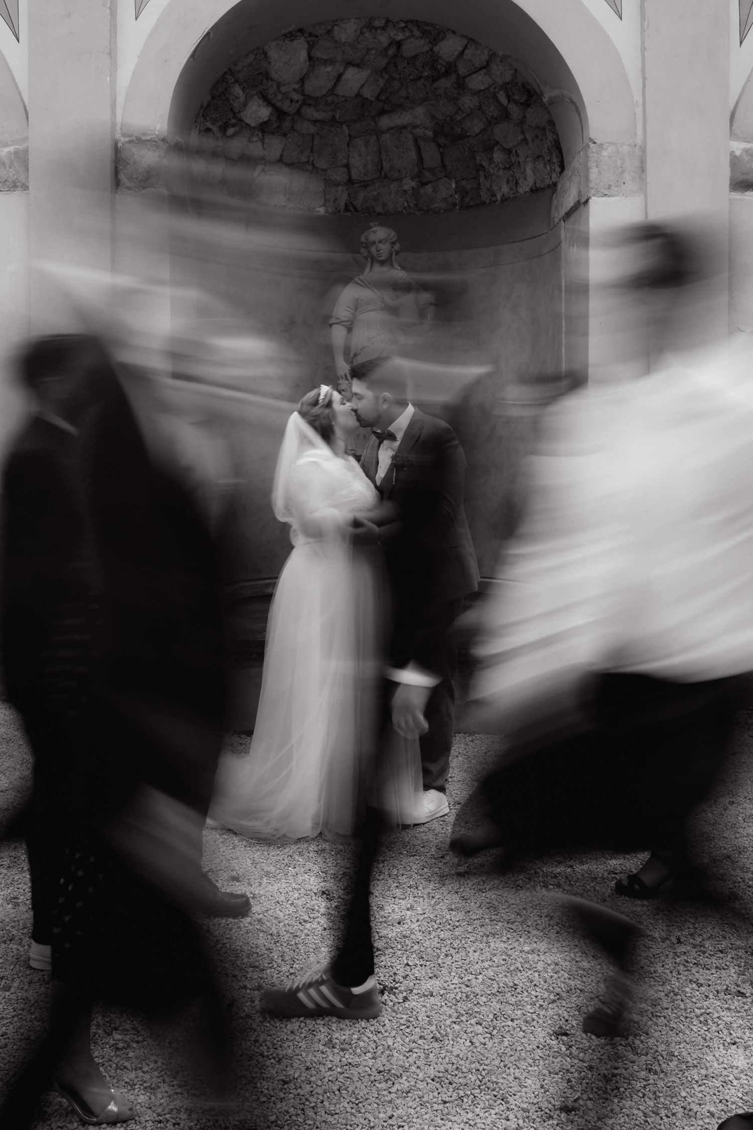 Brautpaar küsst sich während Gäste verschwommen vorbeigehen – emotionale Hochzeitsreportage in Vorarlberg von NuMa Fotografie