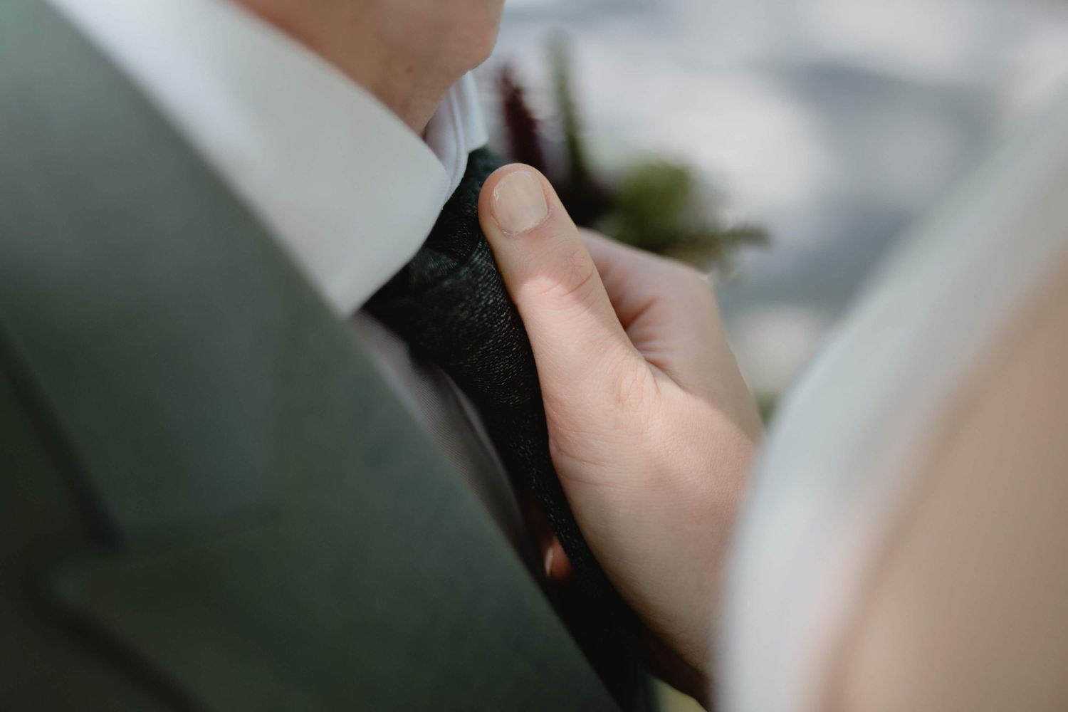 Liebevolles Detail am Hochzeitstag – Anna richtet Markus' Krawatte bei ihrer Hochzeit in Vorarlberg