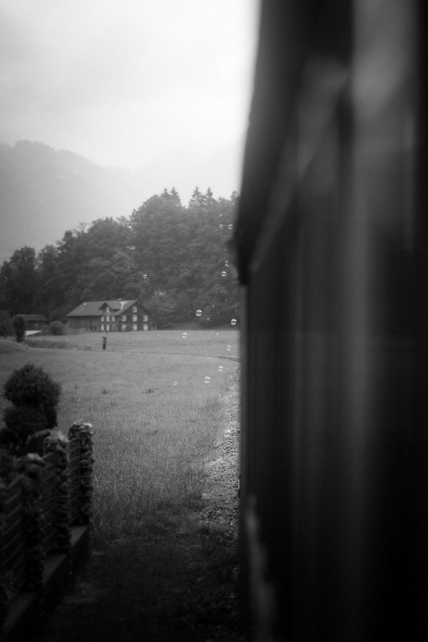 Seifenblasen fliegen durch die Landschaft vor dem Zugfenster – ein verspielter Moment bei der Hochzeit von Jasmin und Stefan.
