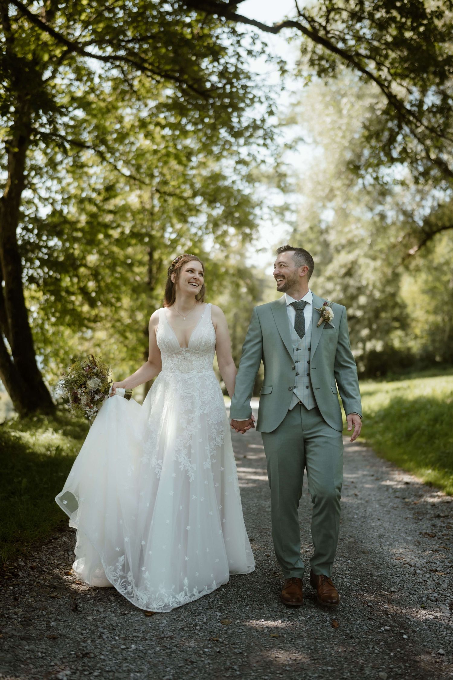 Anna und Markus spazieren lachend durch den Wald – lebendige Hochzeitsreportage in Vorarlberg von NuMa Fotografie