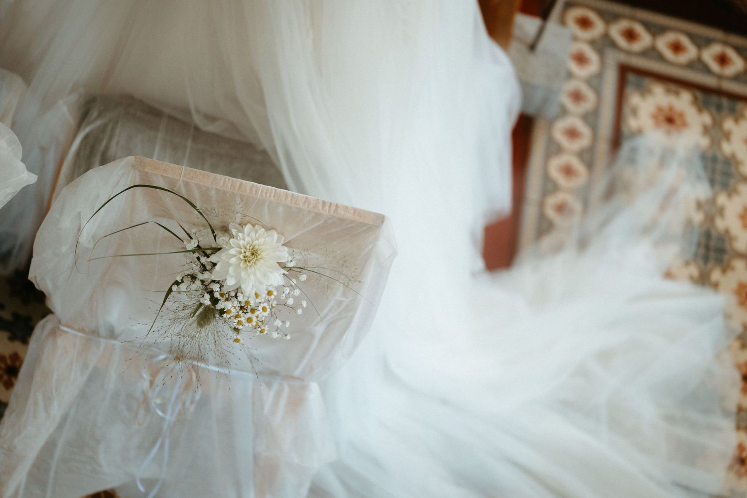 Detailaufnahme einer liebevoll geschmückten Stuhldekoration mit weißen Blumen während einer Hochzeit in Vorarlberg – NuMa Fotografie