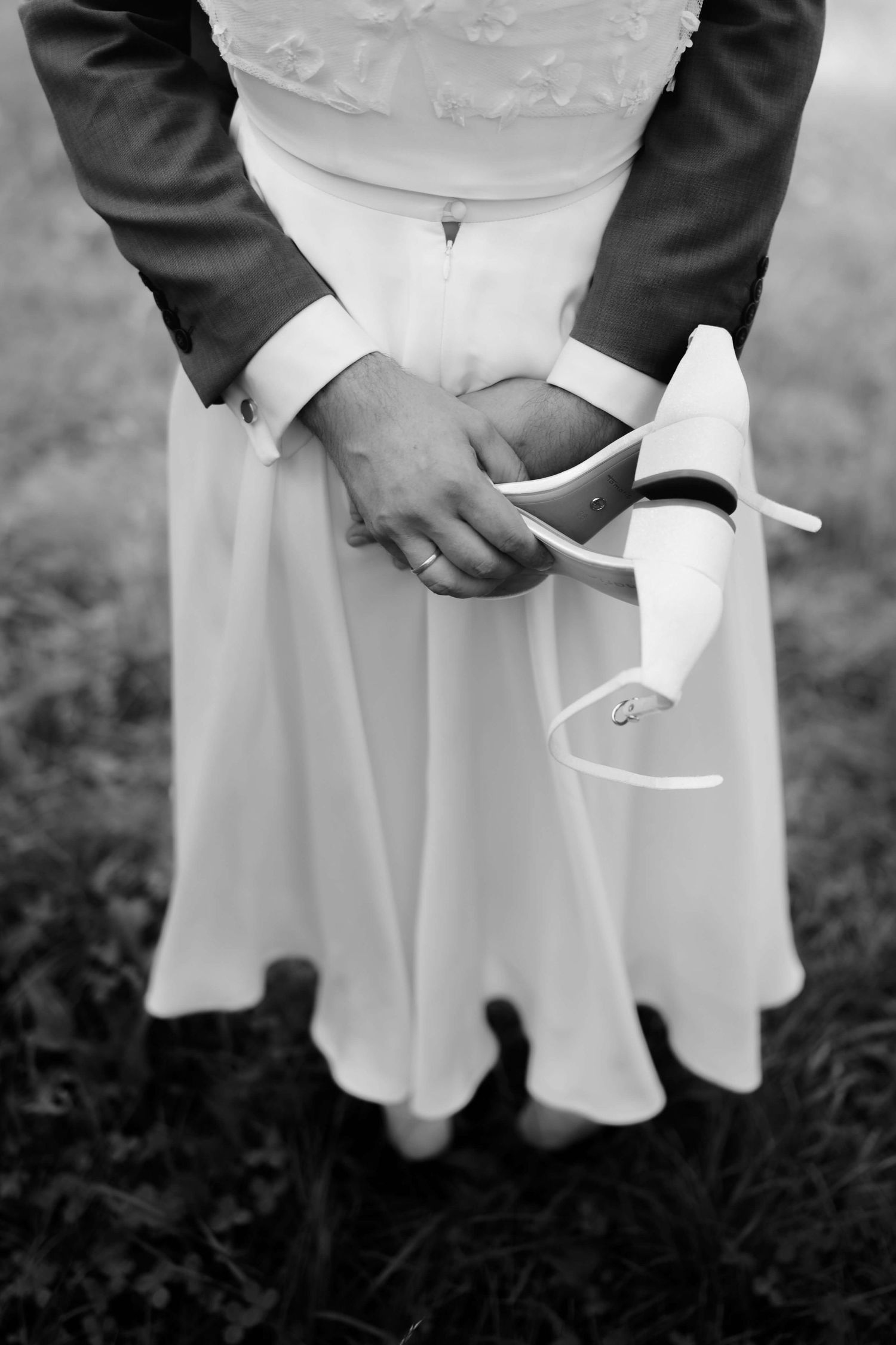 Künstlerische Schwarzweiß-Aufnahme von Brautkleid, Schuhen und Ehering – Hochzeitsreportage aus Vorarlberg von NuMa Fotografie.