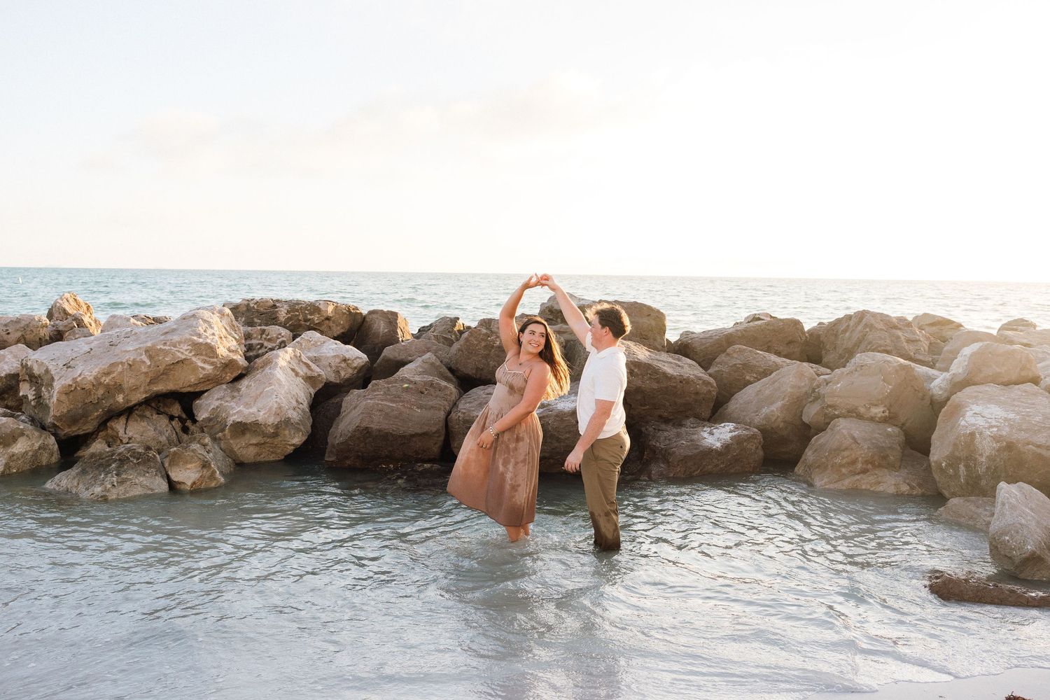 Couple dancing in the ocean at sunset during a St. Pete Beach couples photography session.