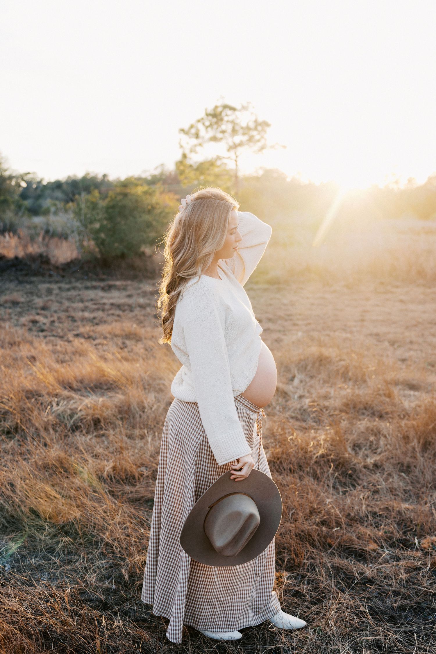 Florida maternity photography session in a golden field at sunset.