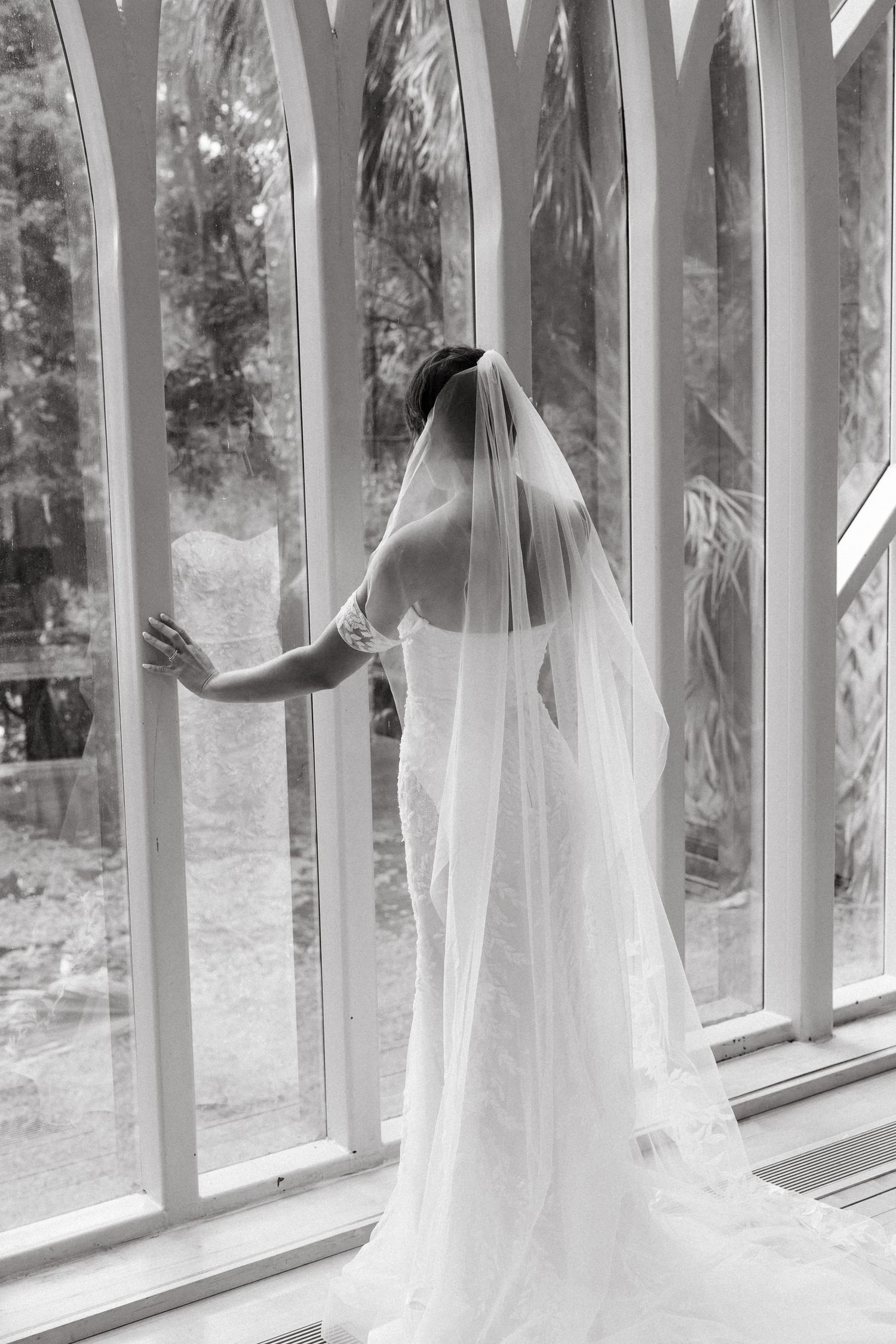 Black and white bridal portrait by arched windows at an elegant Tampa Bay wedding venue.