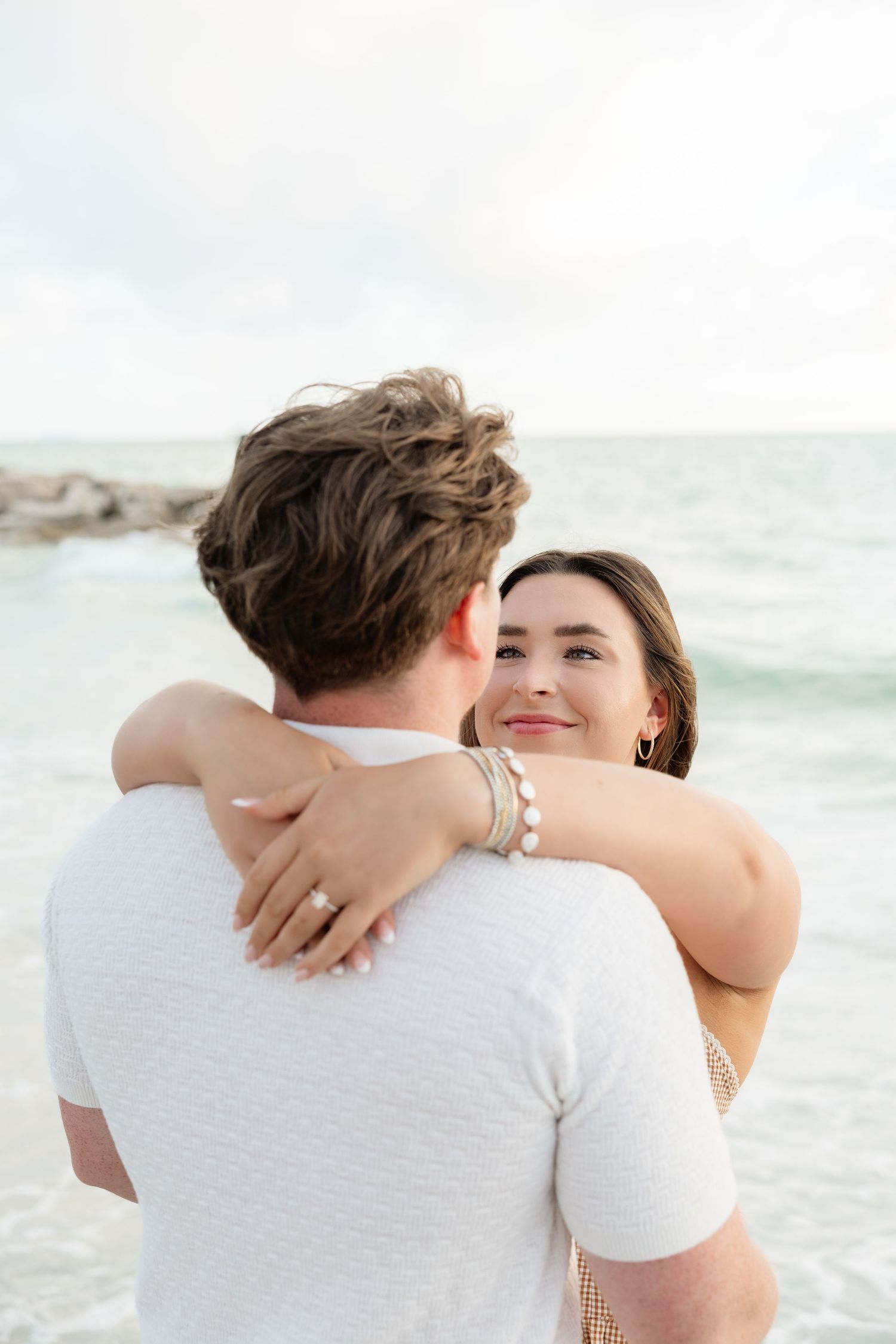 Couple embracing on the beach during a romantic Honeymoon Island engagement session near Tampa Bay.