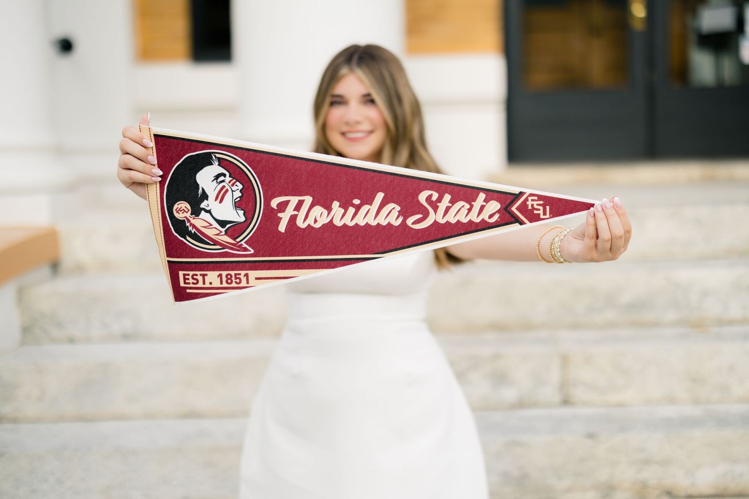 graduating senior holding an FSU pennant during her high school graduation photography session.