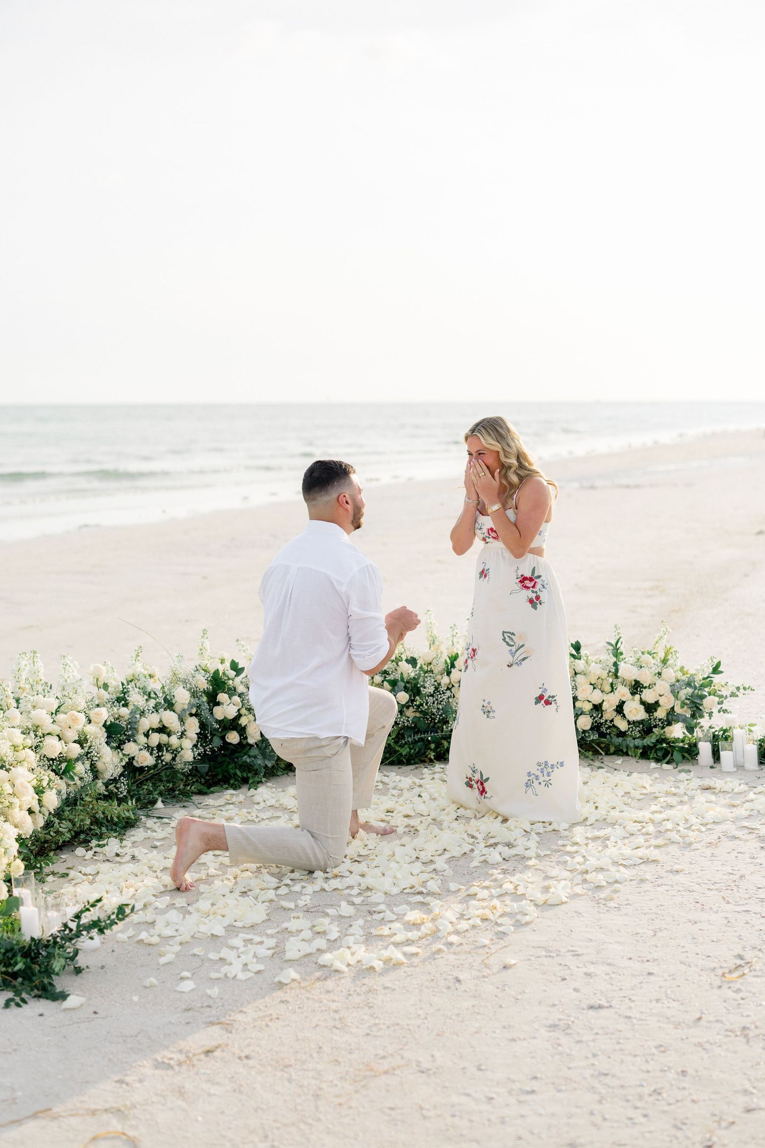 Romantic St. Pete Beach proposal with white roses and ocean views at sunset.