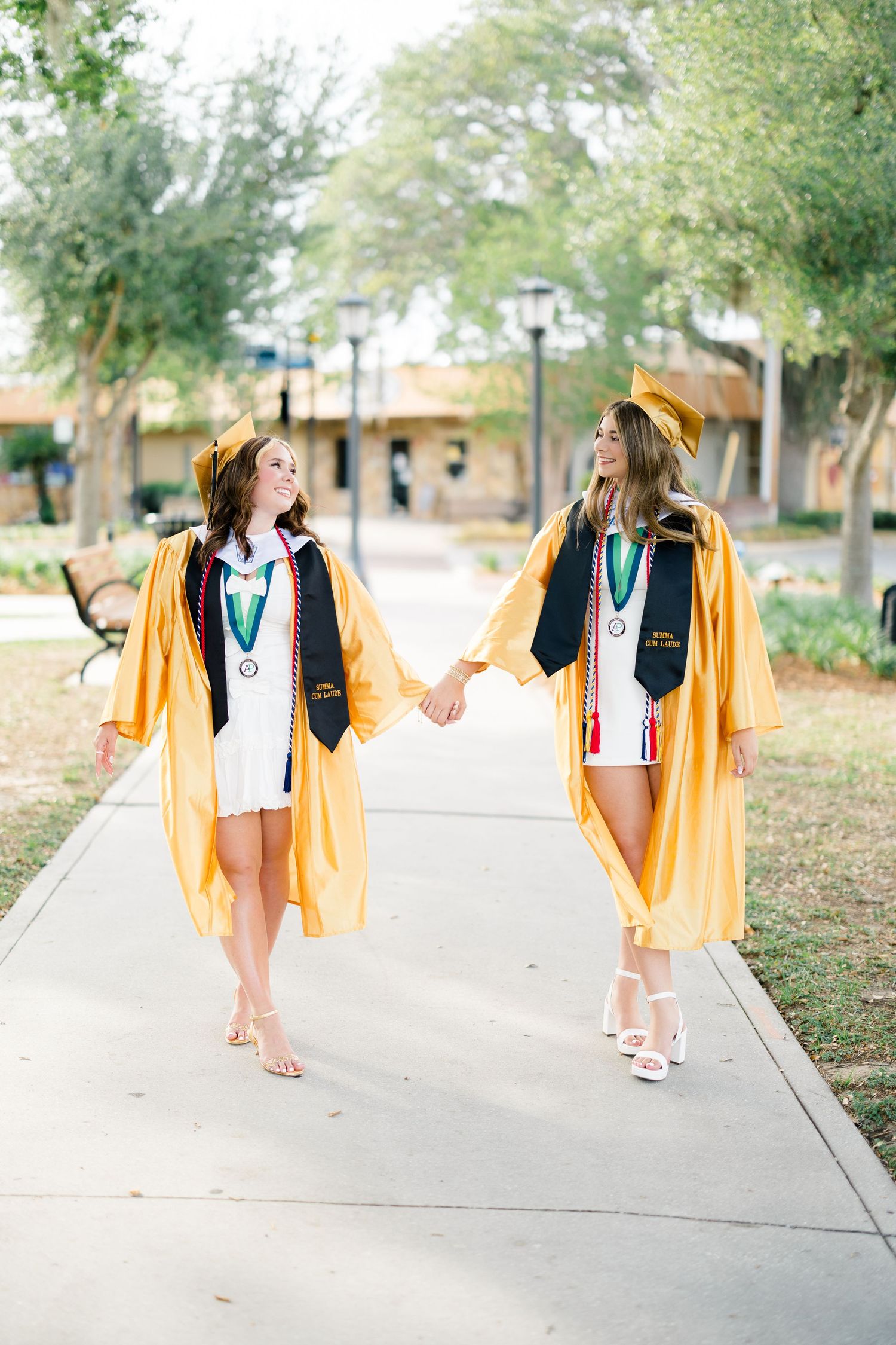 University of Florida graduates walking together in caps and gowns during an USF graduation photography session.