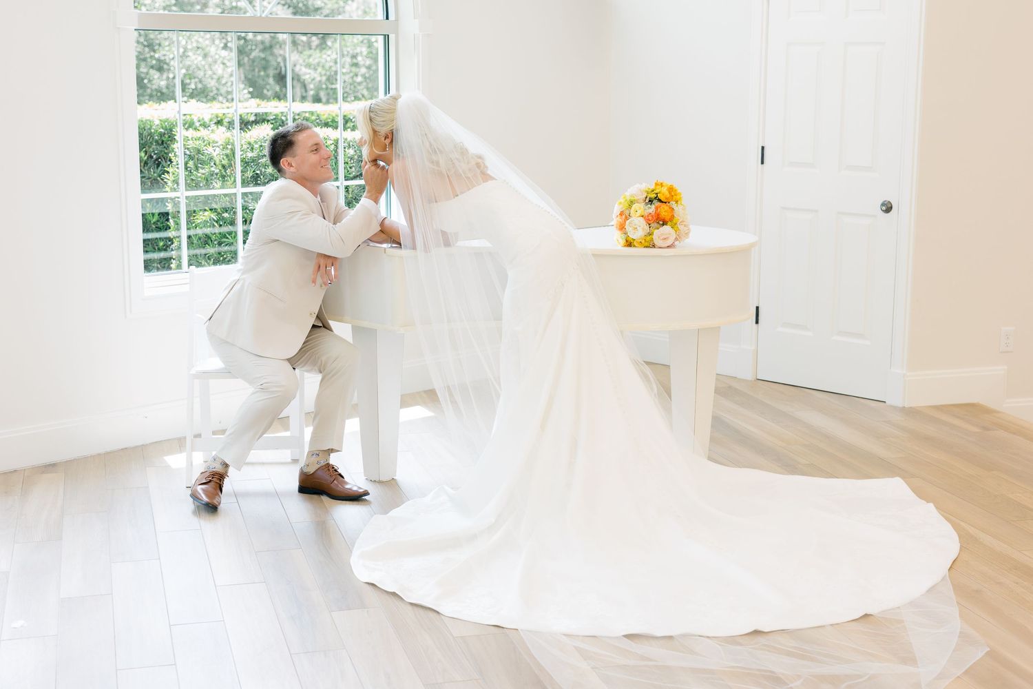 Bride and groom beside a white piano during an elegant Florida wedding celebration.
