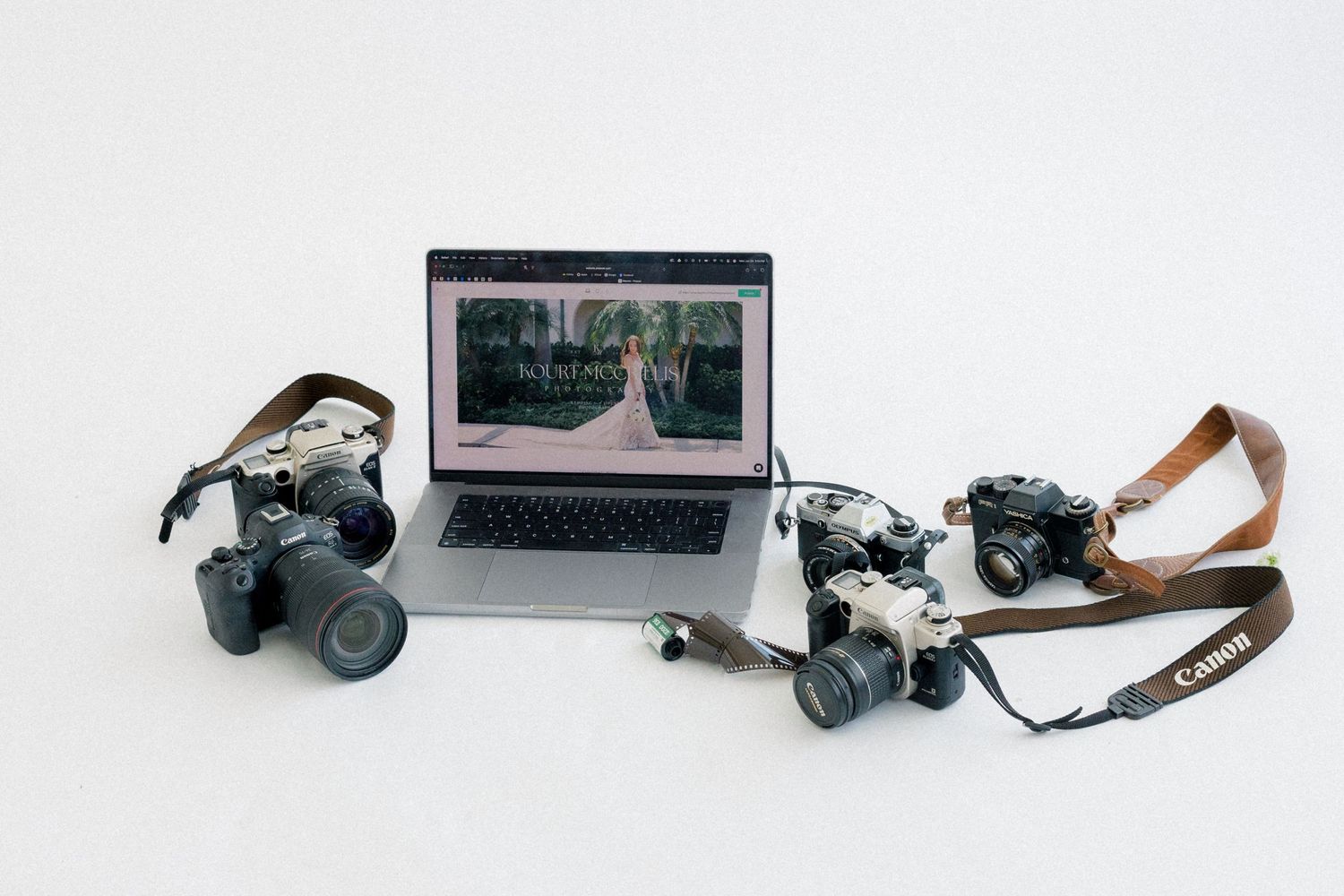 Three Canon cameras and a MacBook laptop displaying a wedding photography website on a white background.