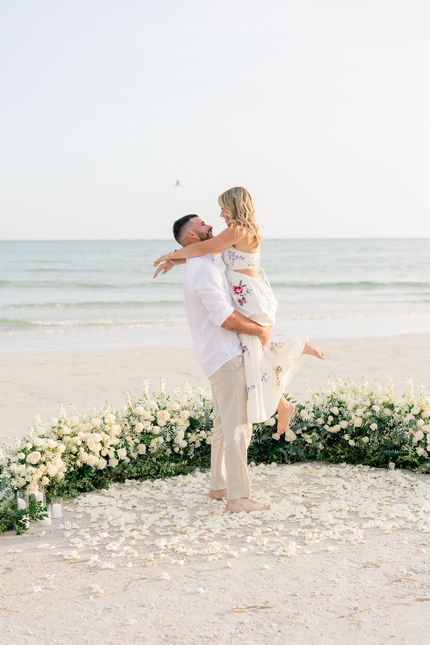 Surprise proposal on St. Pete Beach with white roses and ocean views at sunset.
