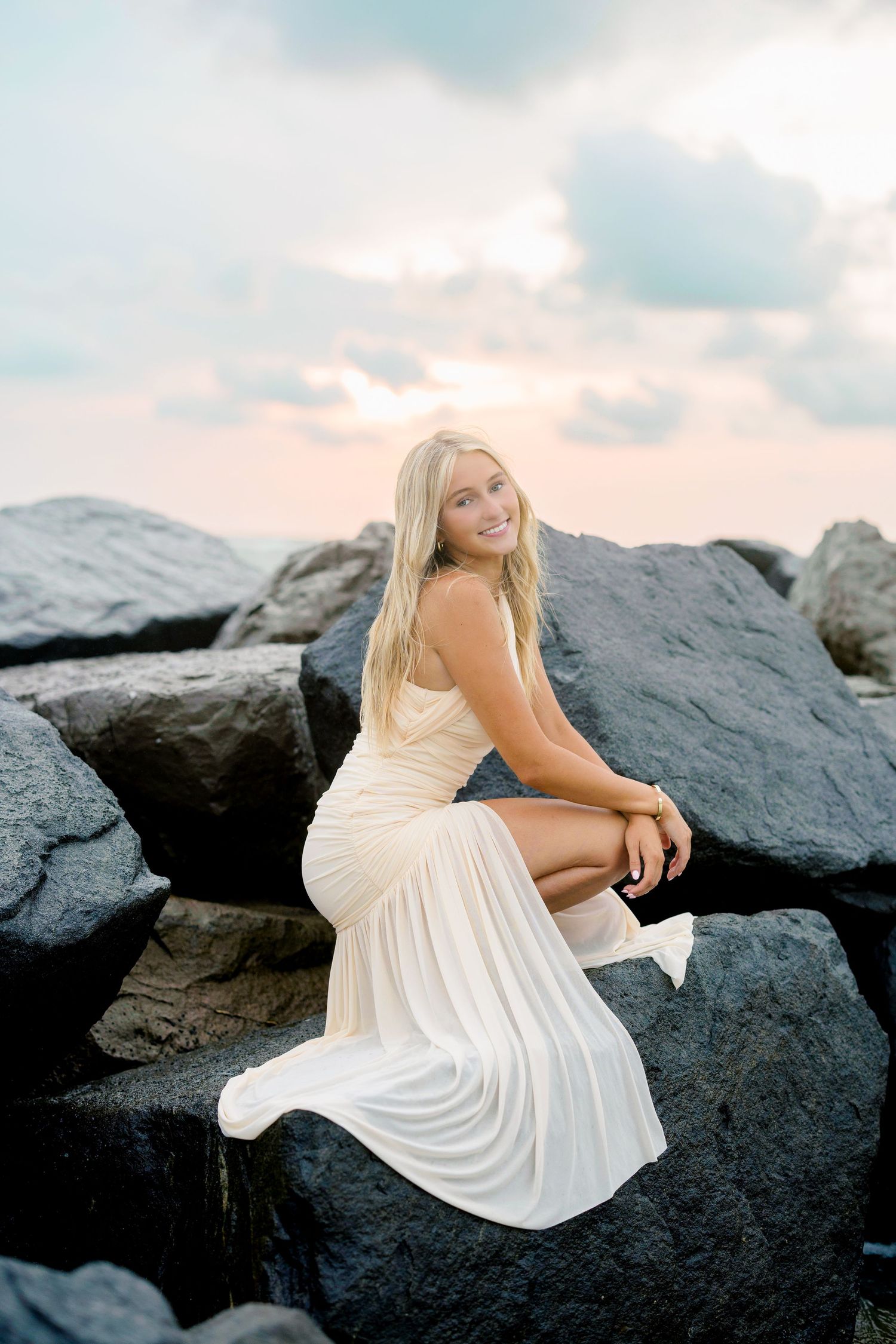 Senior portrait in a white dress on coastal rocks at sunset during a Florida beach senior session.
Upham Beach