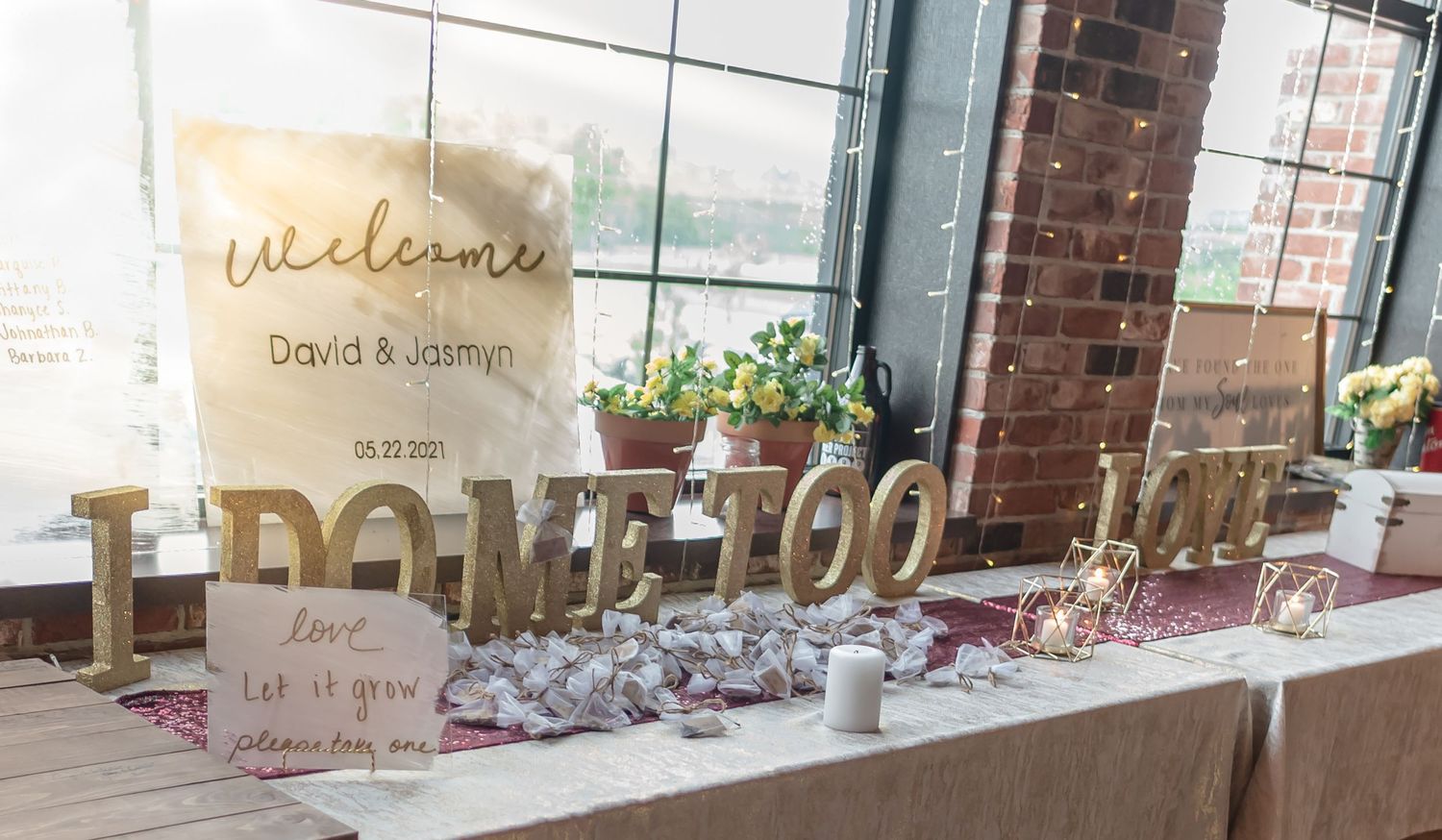 A wedding welcome table with golden 'name too' signage and decorative elements.