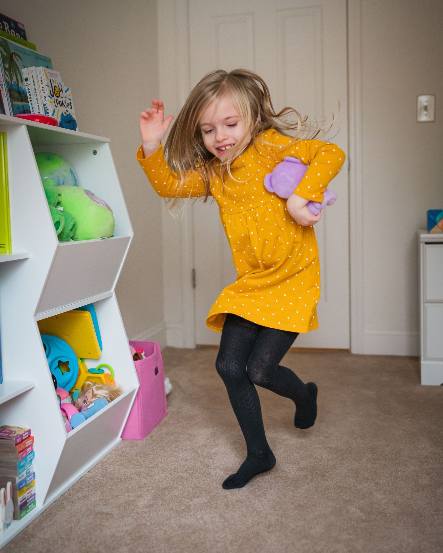 A sequence of photos showing someone in a yellow top dancing and jumping playfully near white storage shelves.