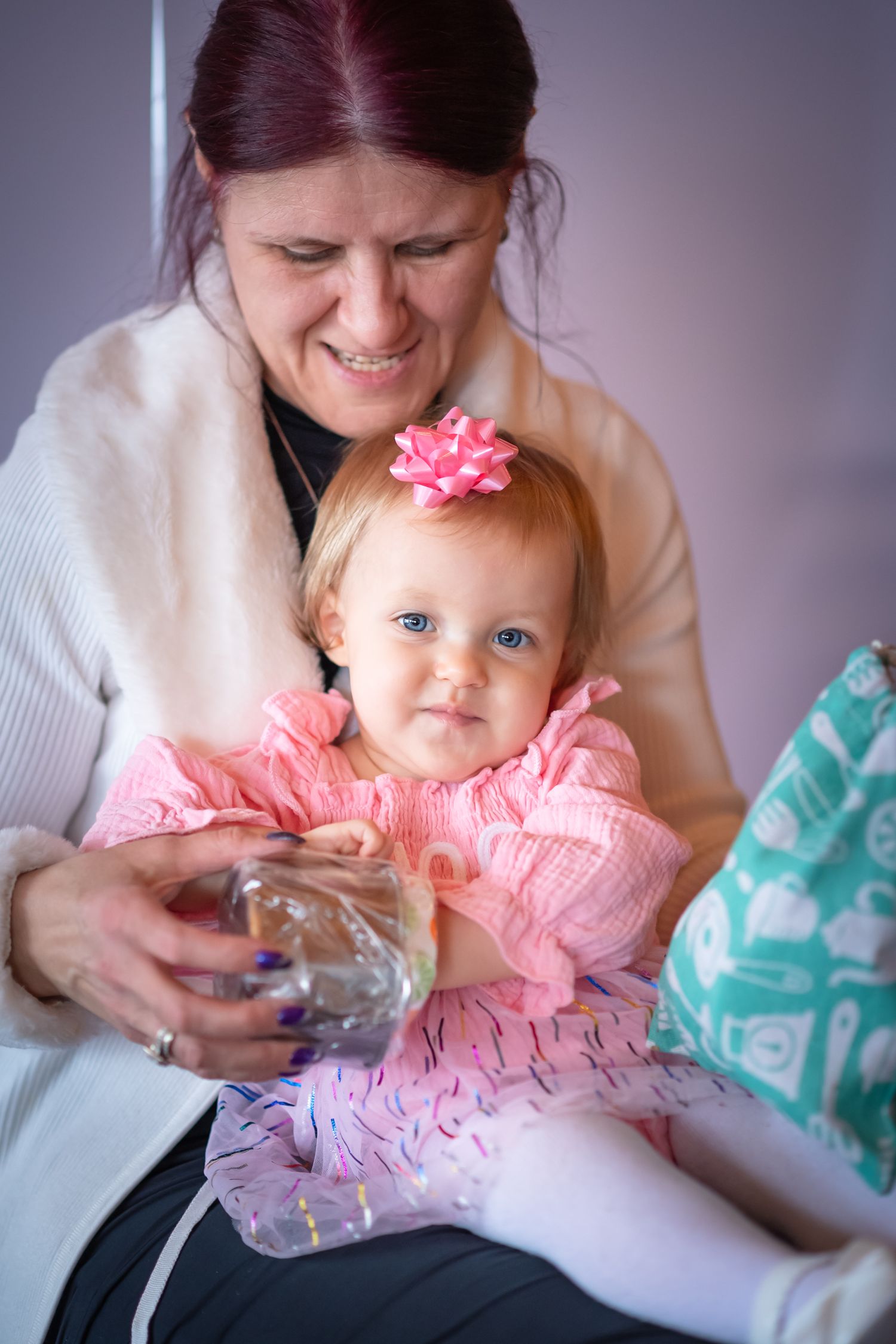 A series of photos showing a baby in a pink tulle dress being tickled and smiling during a playful moment.