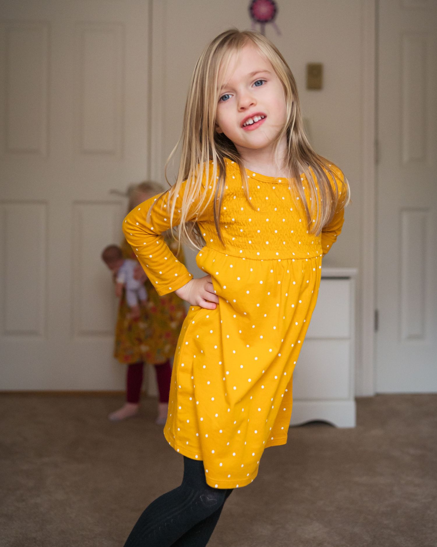 A child in a bright yellow polka dot shirt poses playfully in a series of candid indoor shots.