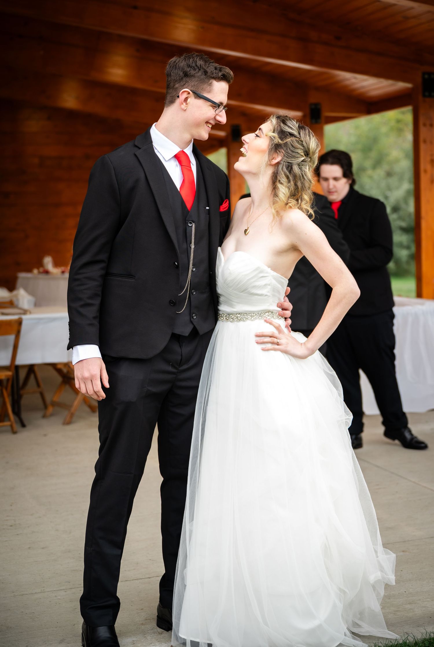 A couple laughs together during their first dance, with the bride wearing an elegant white tulle gown.